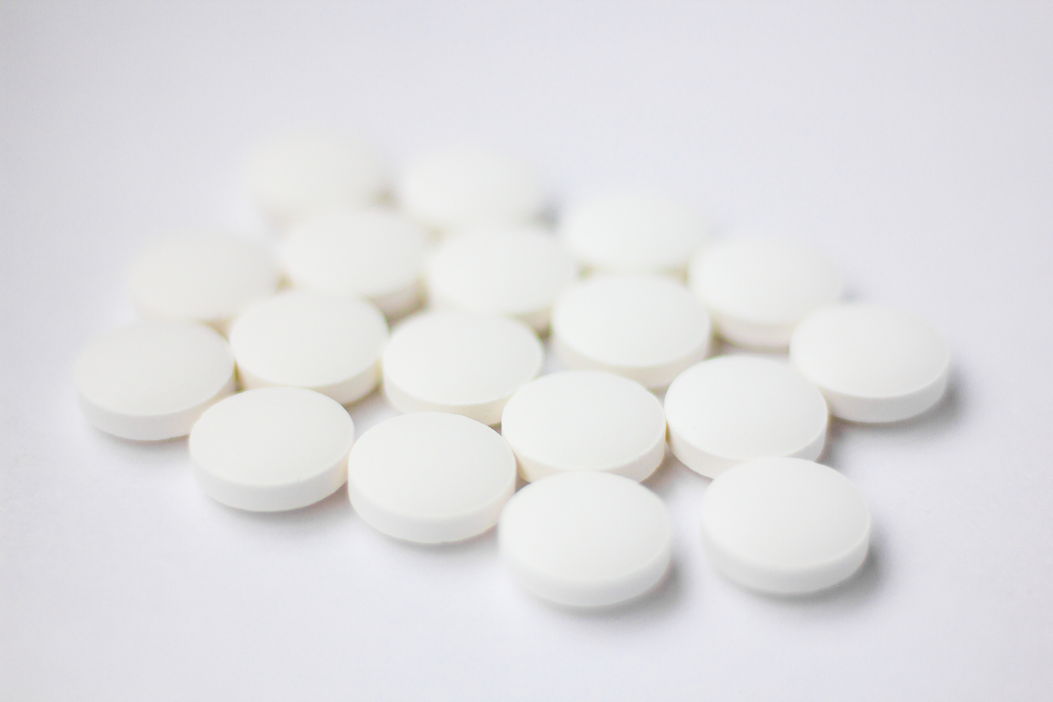white pills on a white background. a cure for pain. health and m