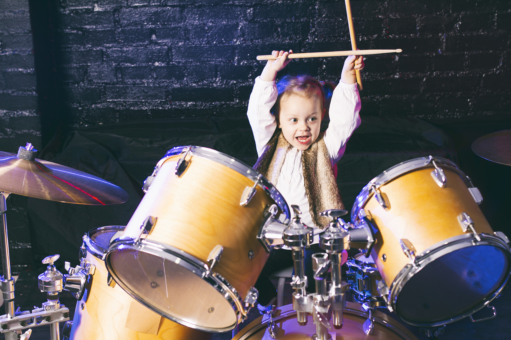 little girl playing drums
