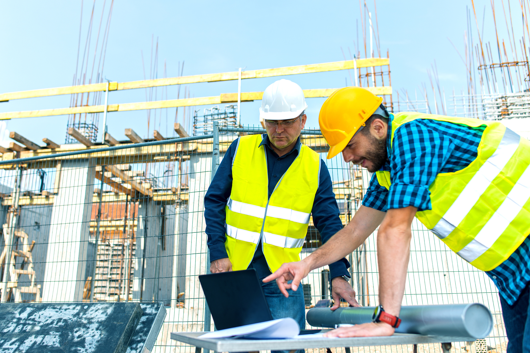 engineer and architect looking at blueprints on construction sit