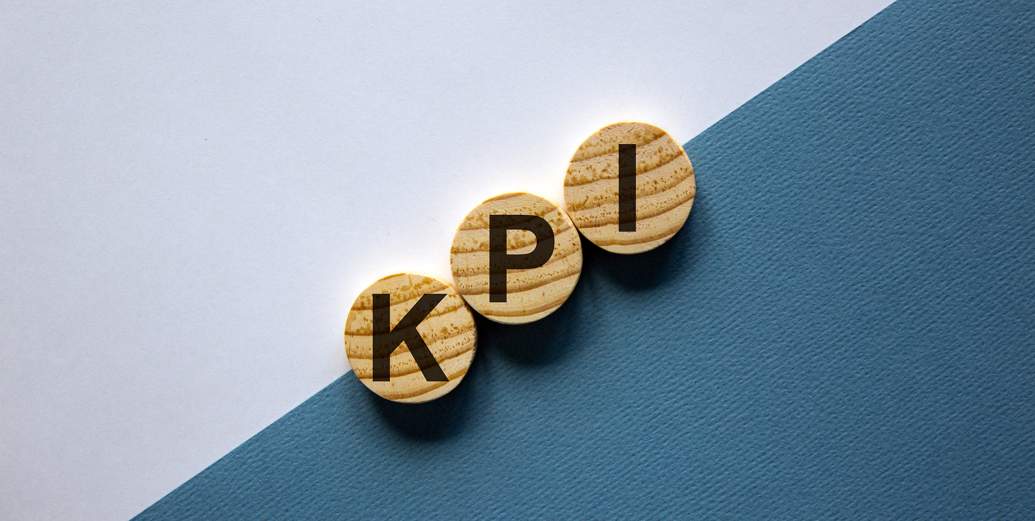 wood circles with word 'kpi' on paper blue and white background,