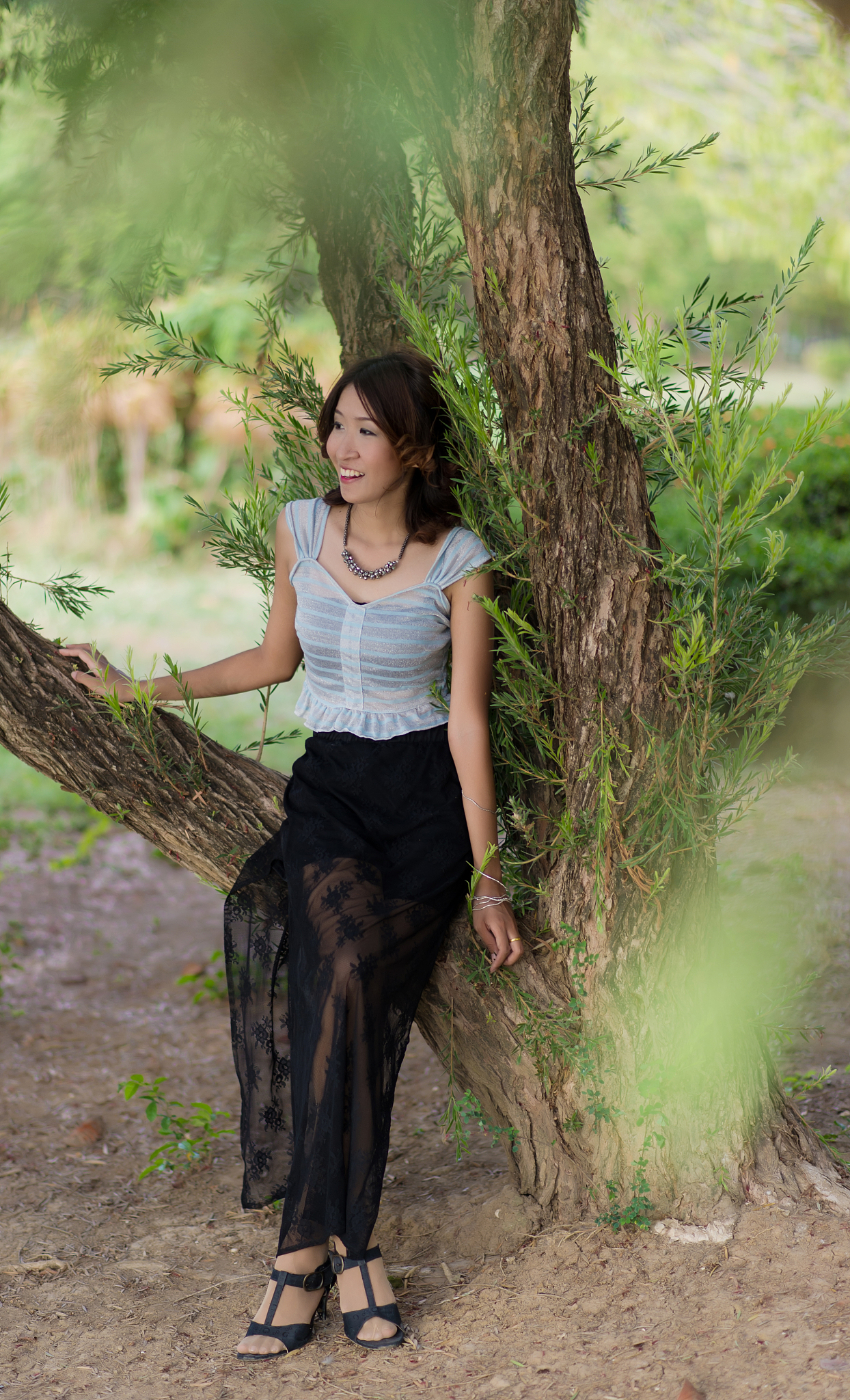 smiling young woman sitting on tree