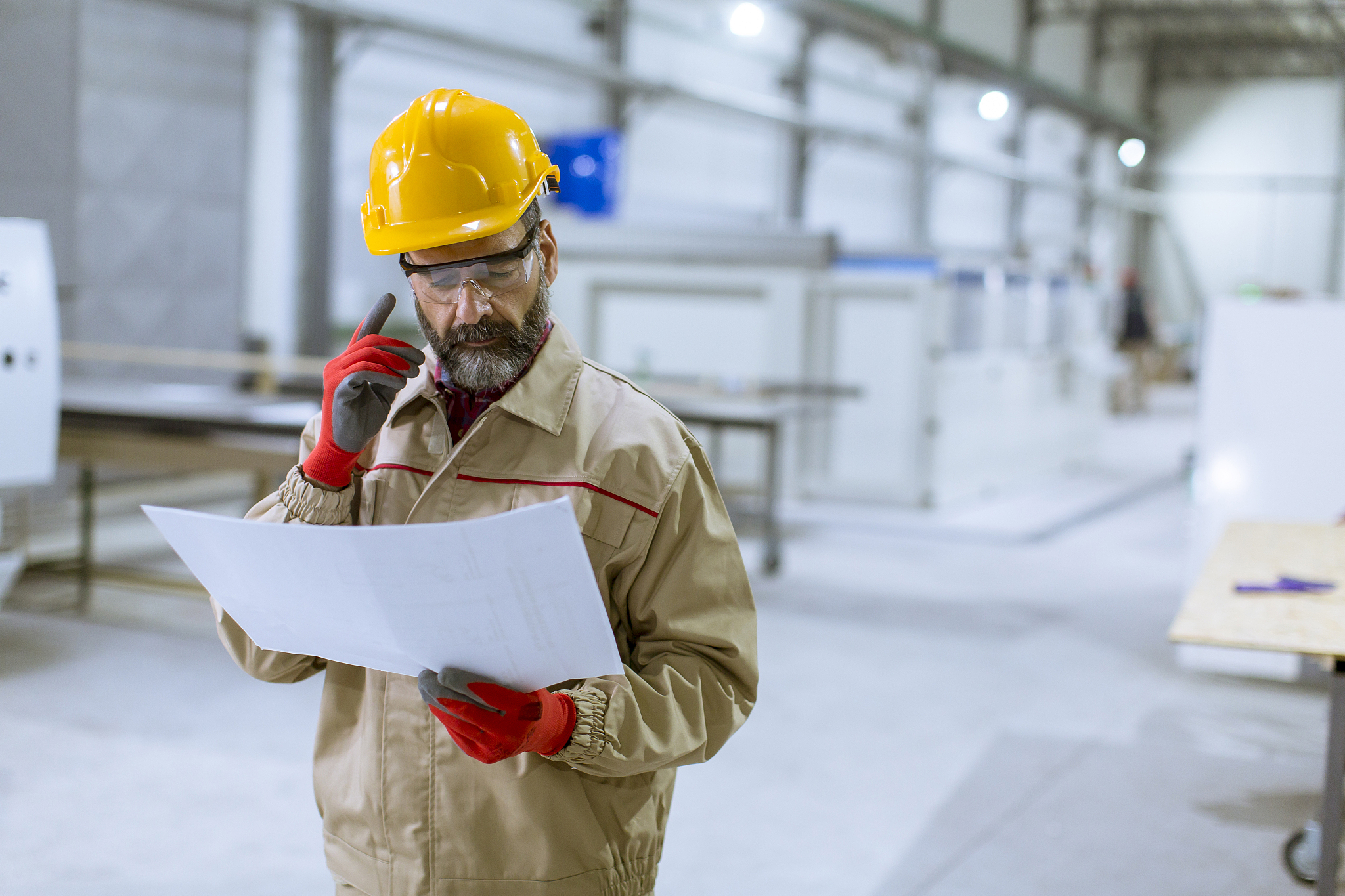 handsome mature engineer looking at plan in the factory