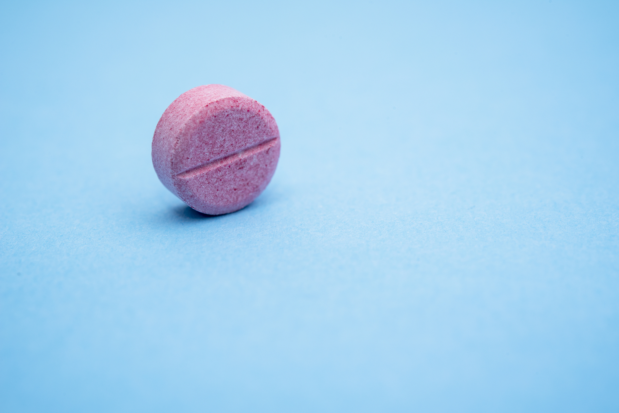 one round pink pill on the rib, close up