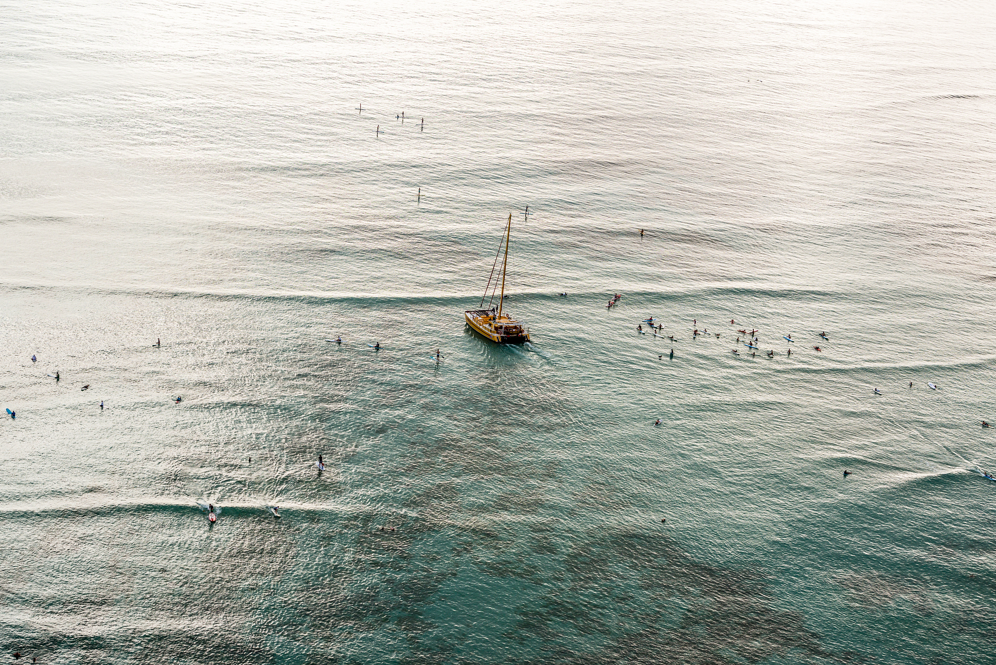 catamaran and people on paddleboards in ocean, hawaii