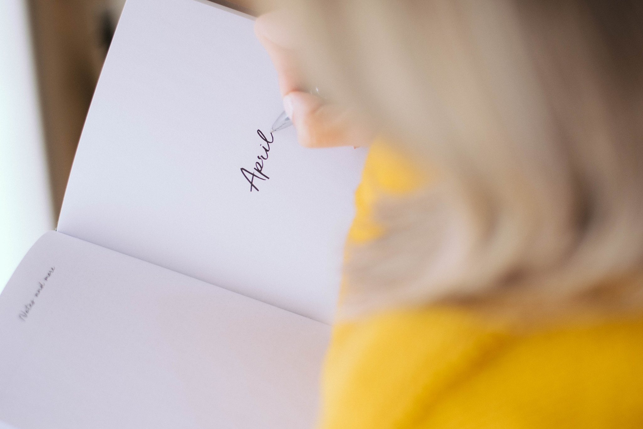 women holding a pens writing a notebook