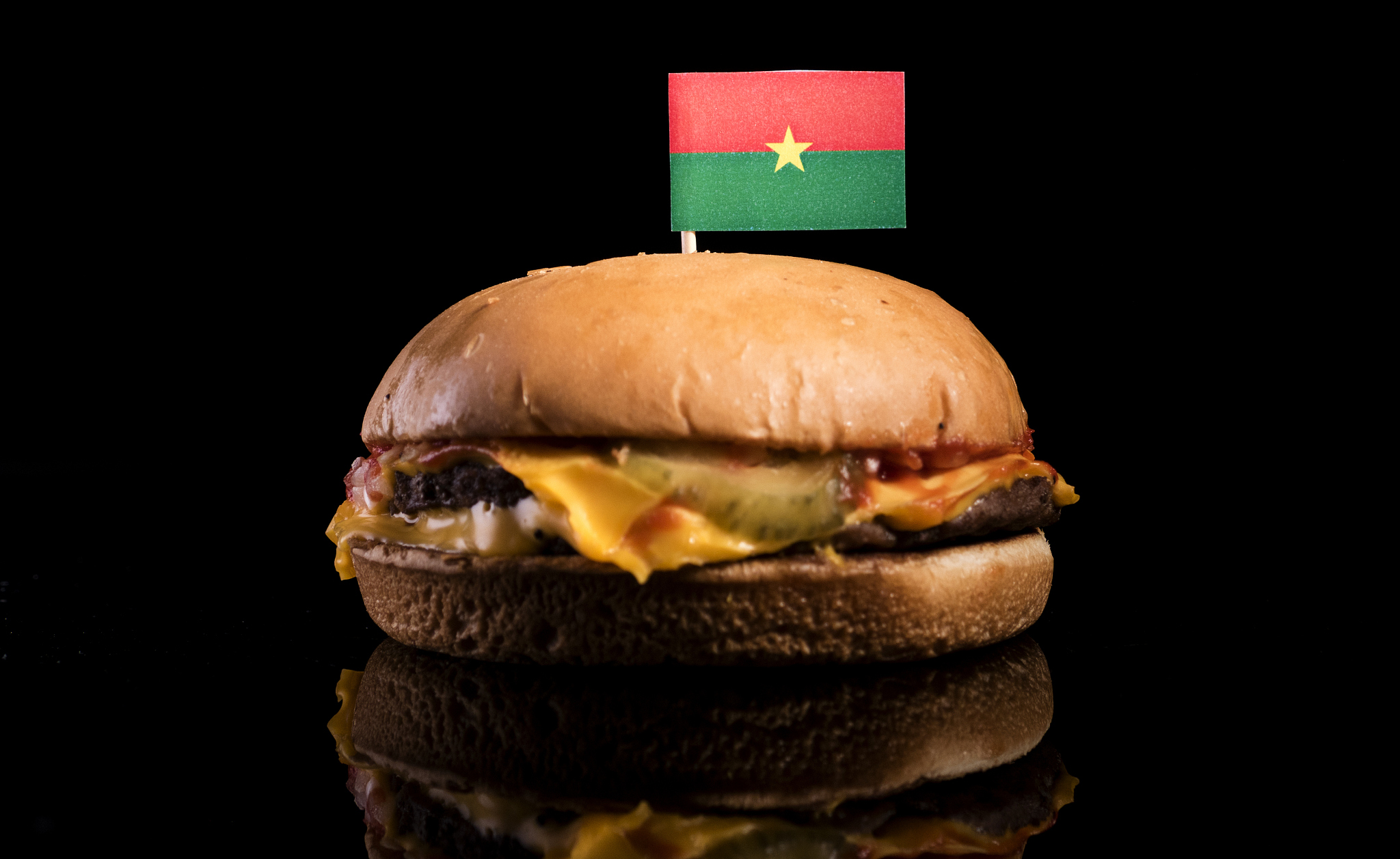 burkina faso flag on top of hamburger isolated on black backgrou