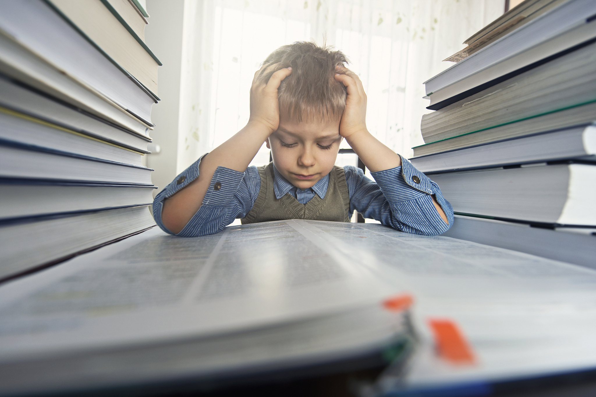 overworked little boy trying to learn too much