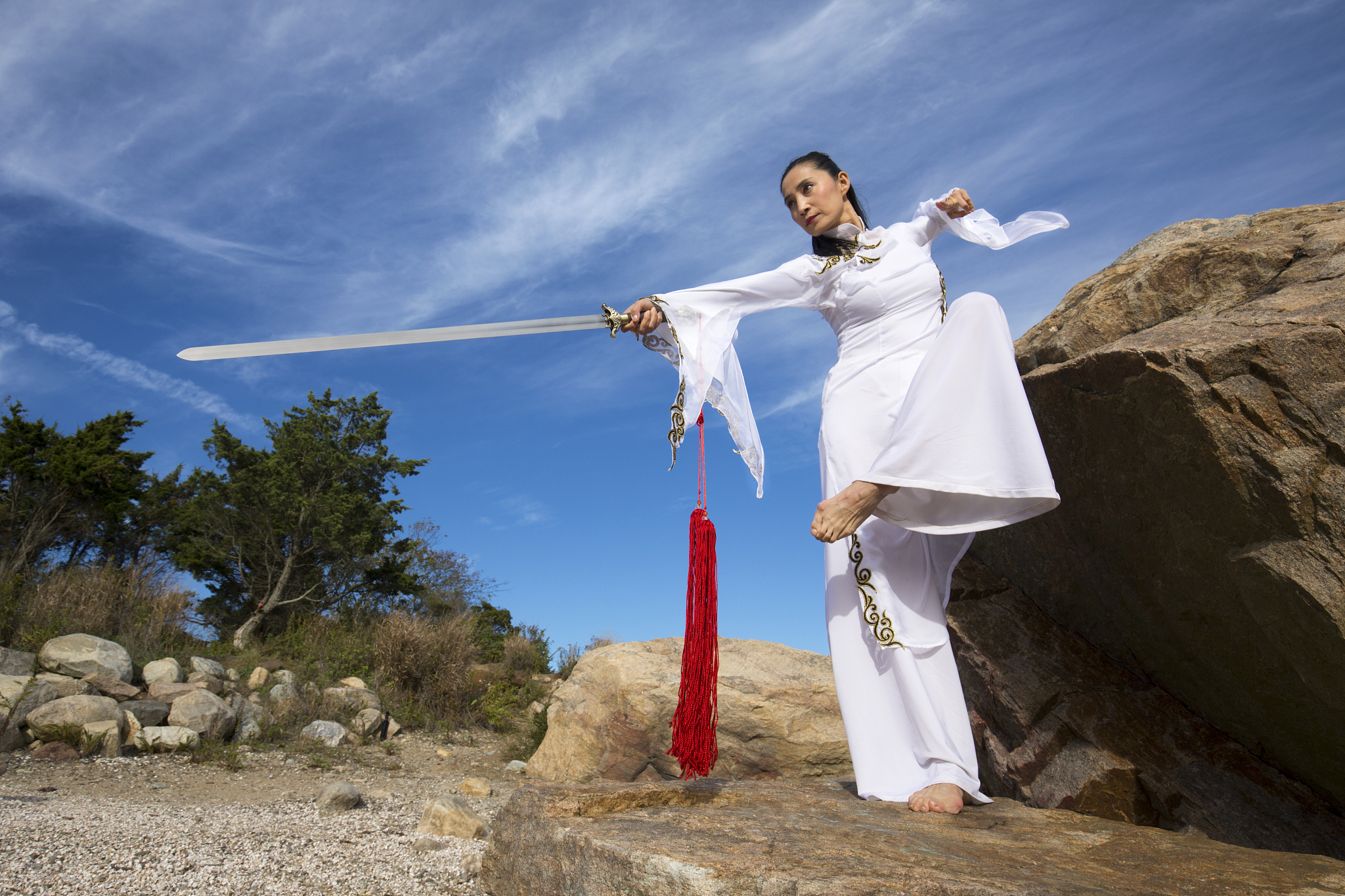 young woman dancer with a sword on a connecticut beach.