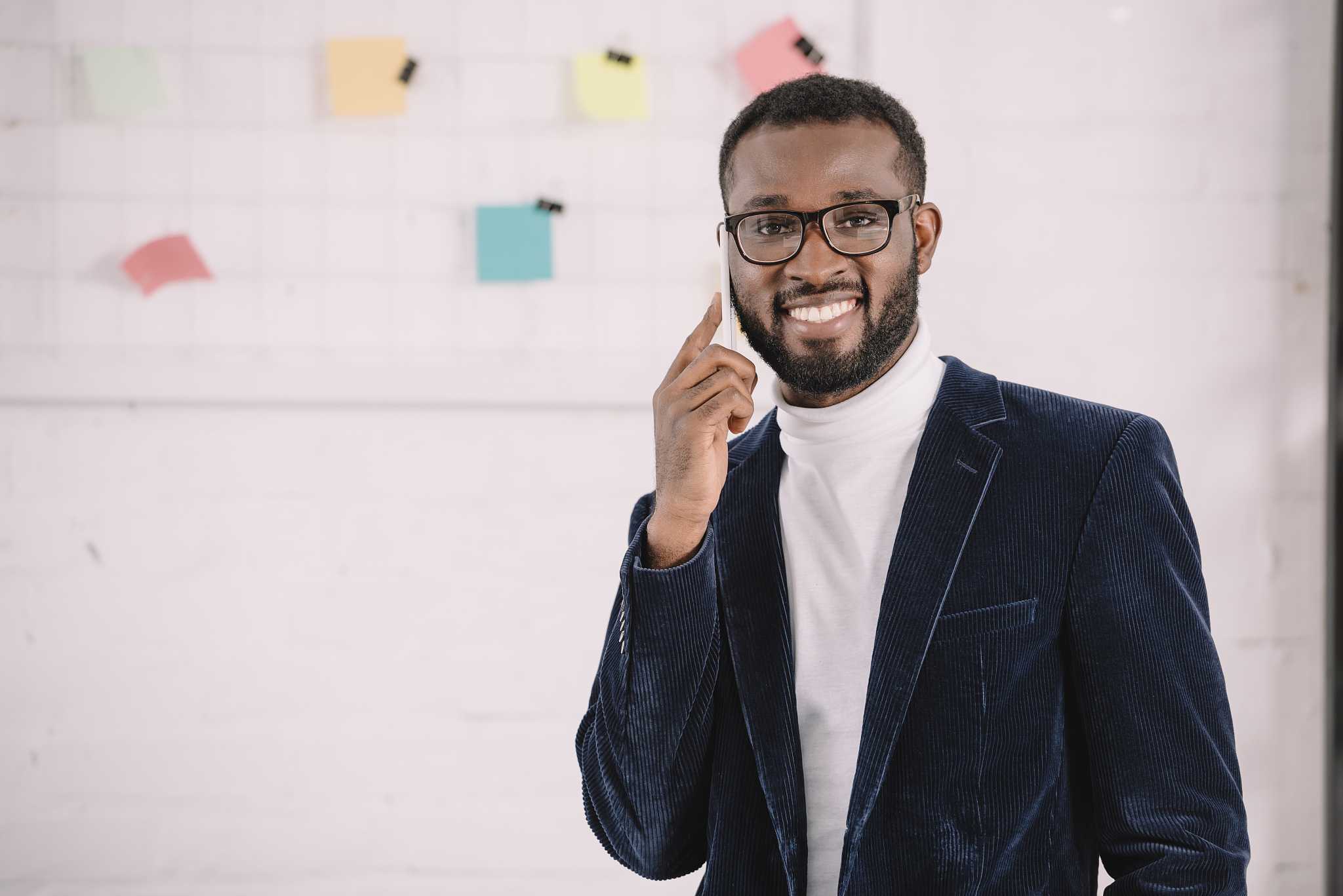 smiling african american businessman in velvet jacket talking on