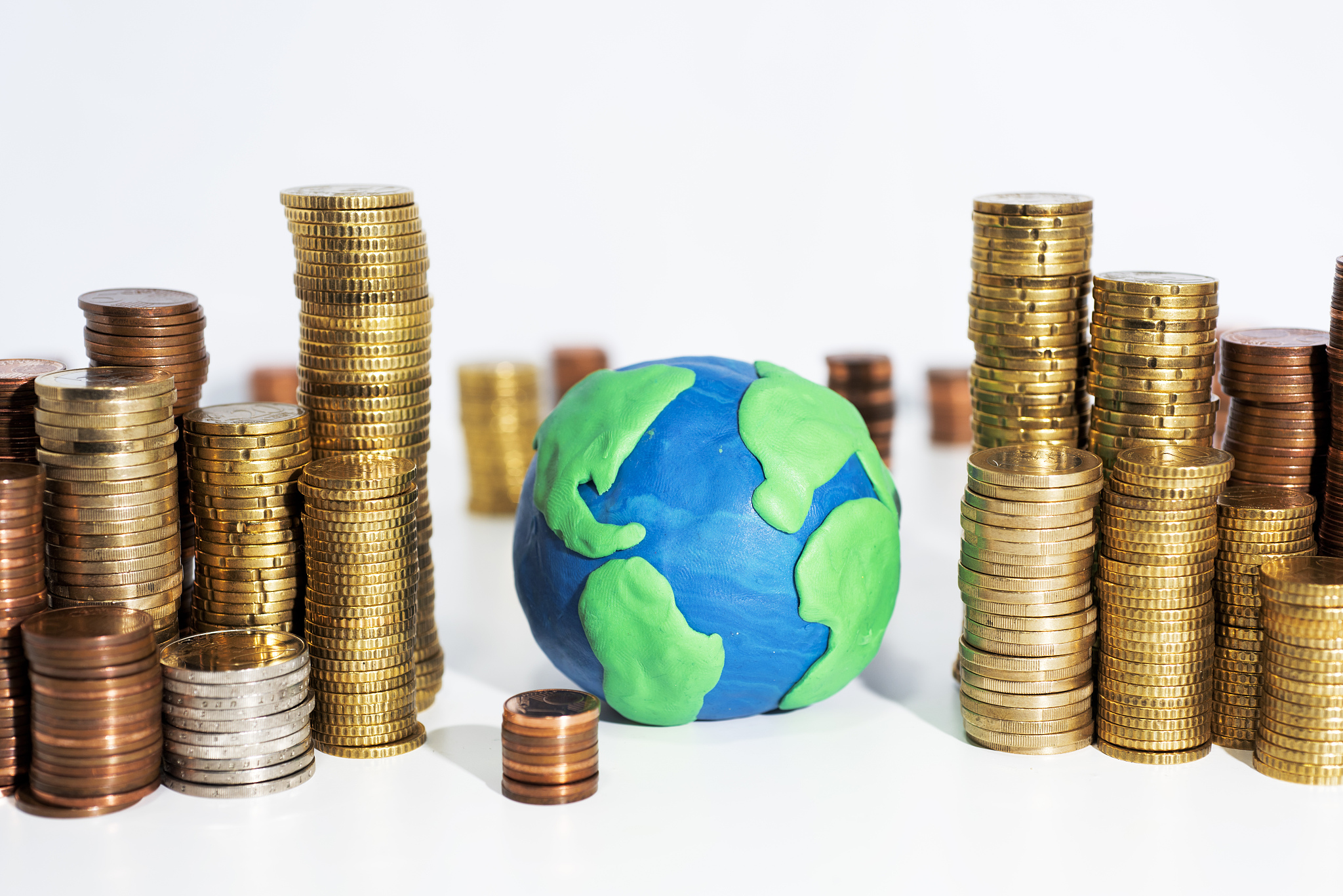 a lot of coins on white table with earth model. abstract photo o
