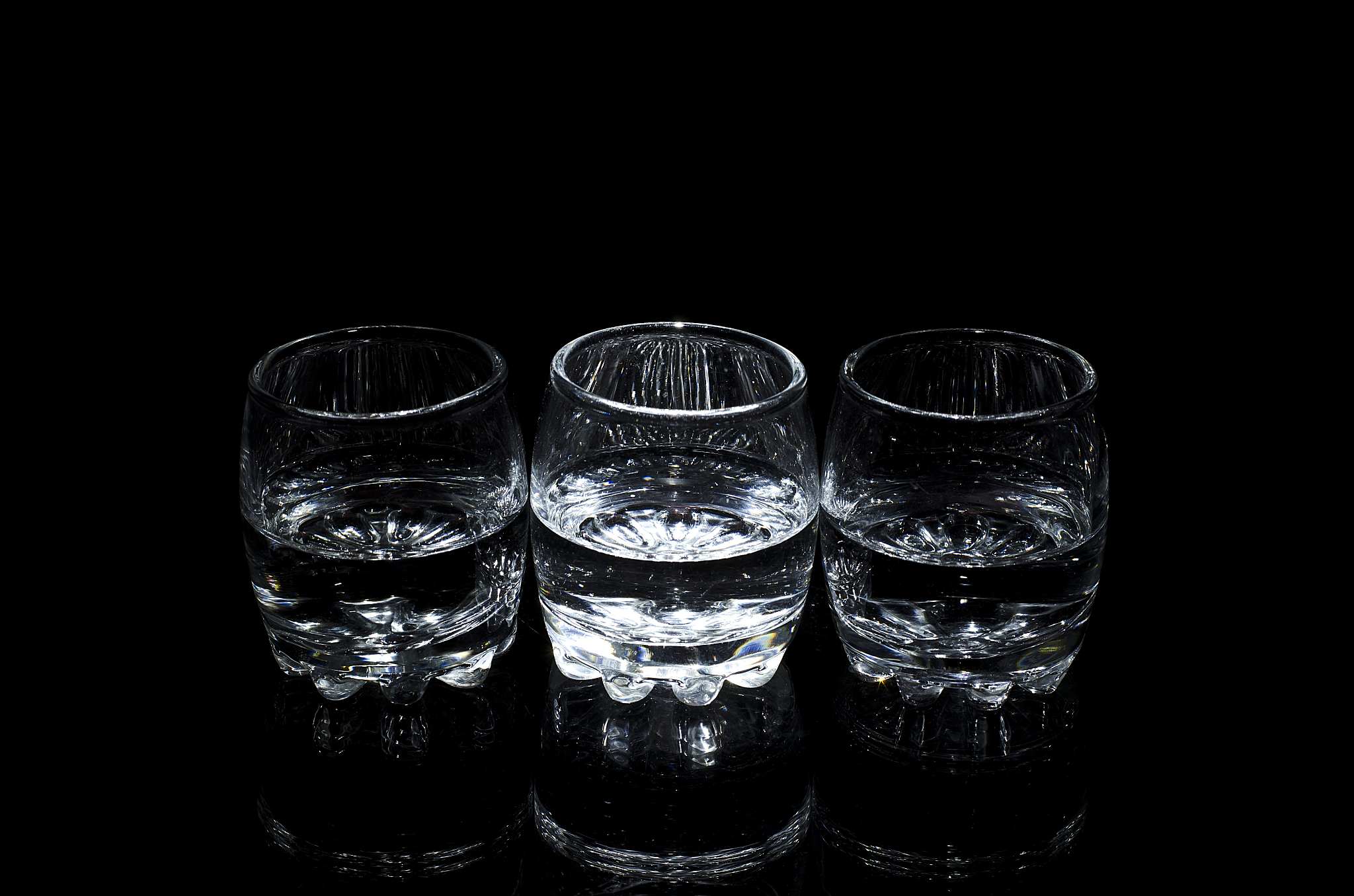 three glasses of liquor, isolated on a black background