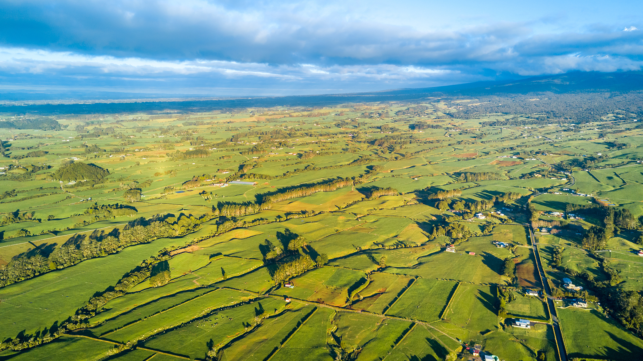 aerial view on a farmland with stock paddocks at the foot of mou