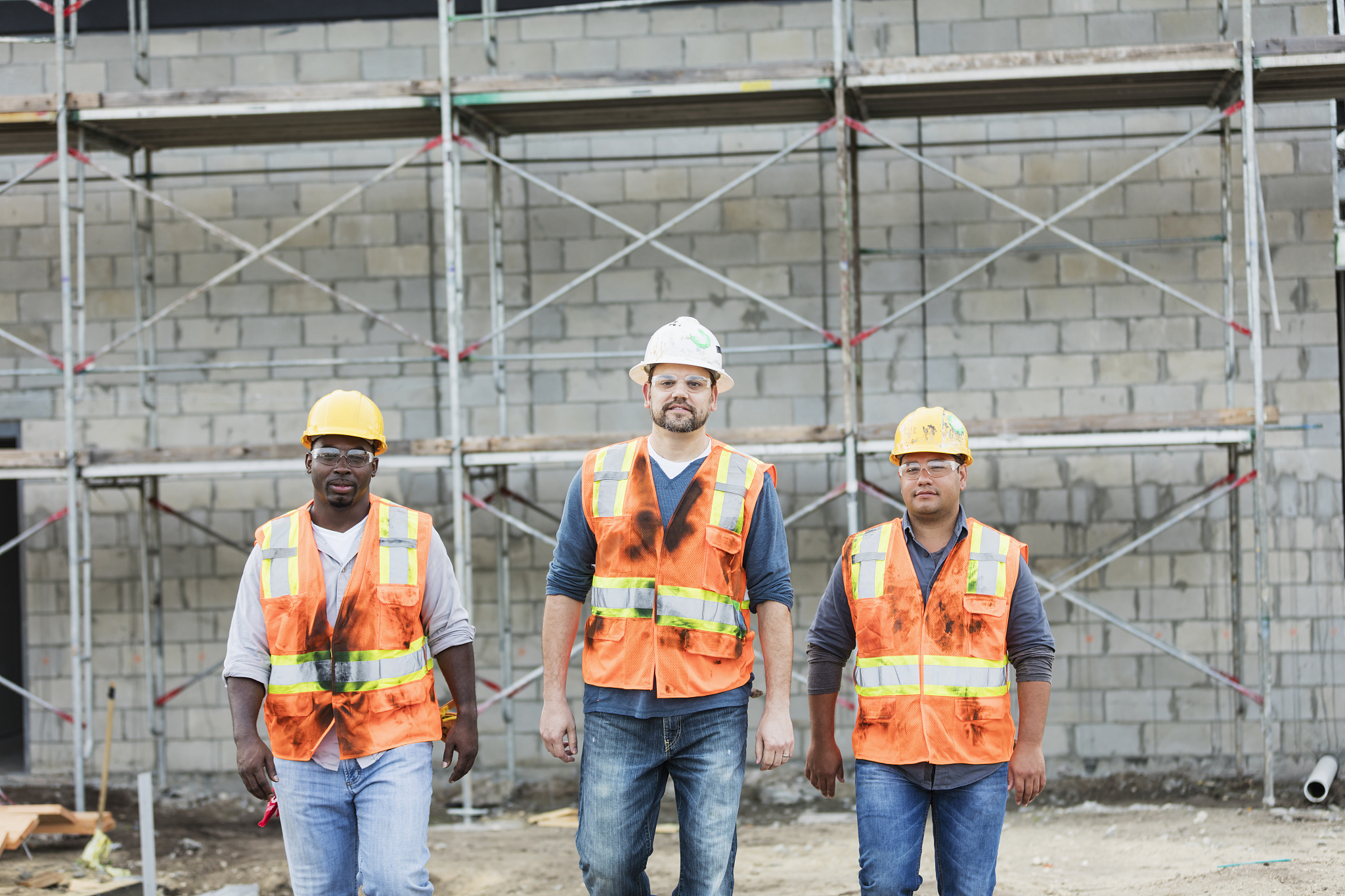 three construction workers walking toward the camera