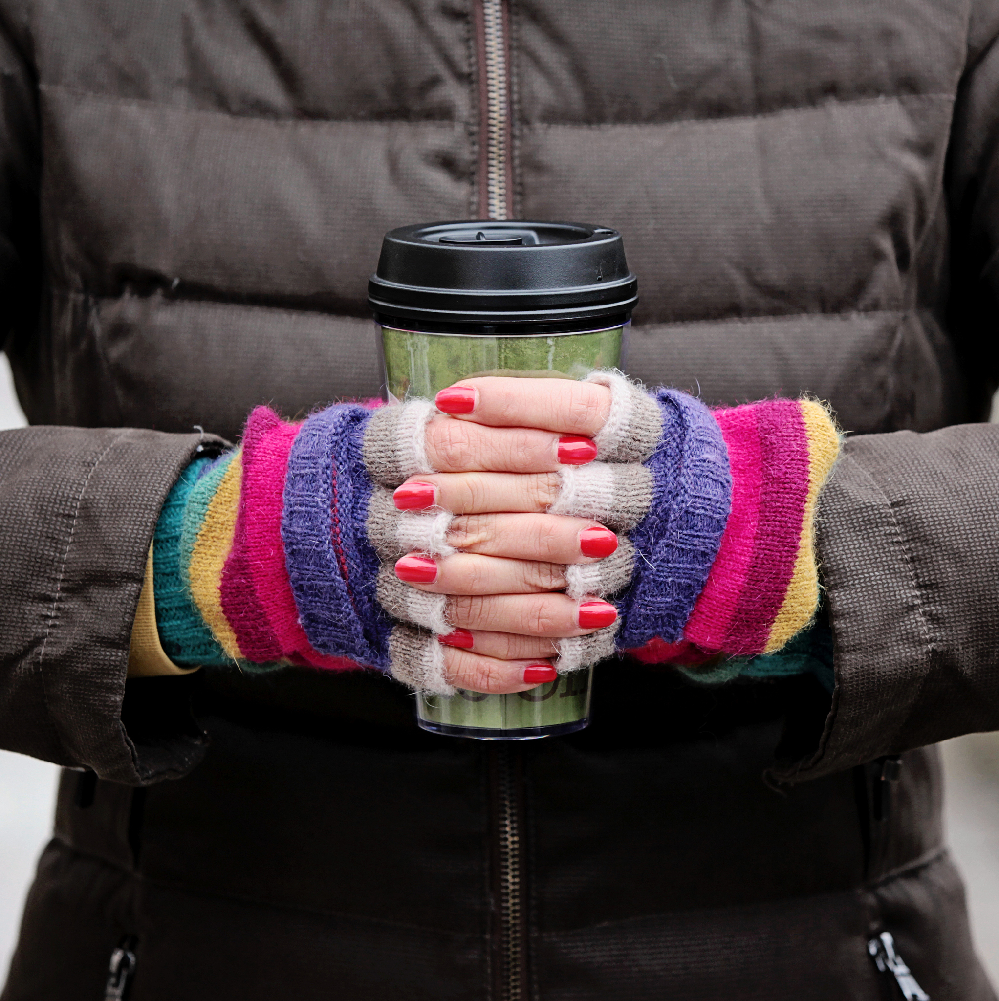 colorful hands holding carry cup.