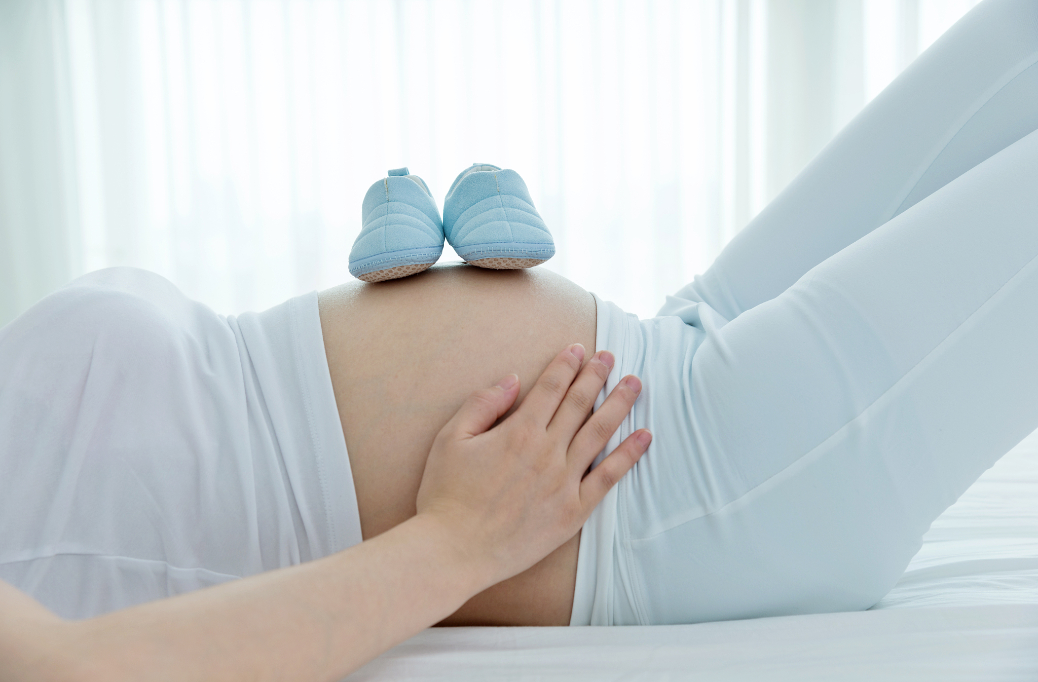 baby shoes on pregnant woman's tomach