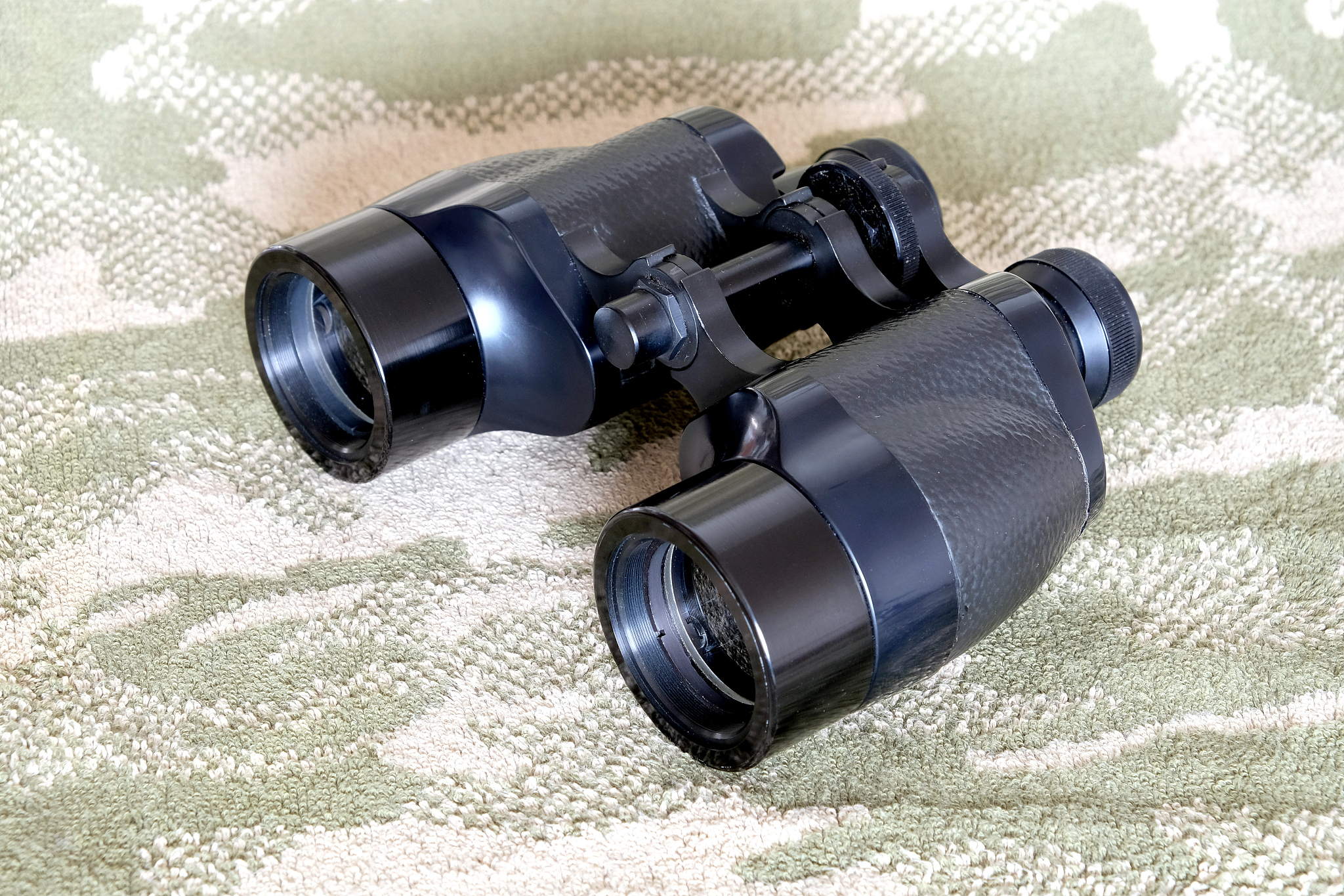vintage porro prism black binoculars on camouflage background