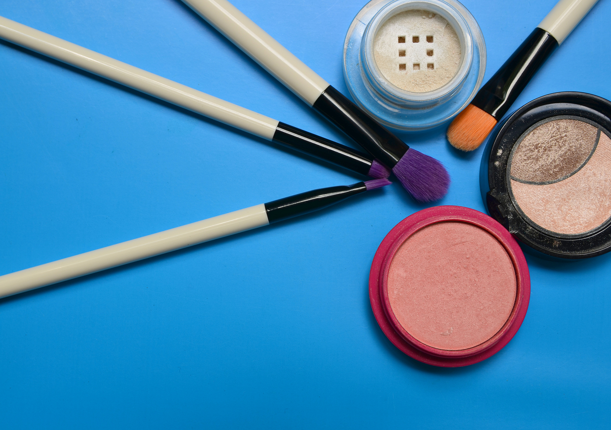 various makeup products on a blue background.