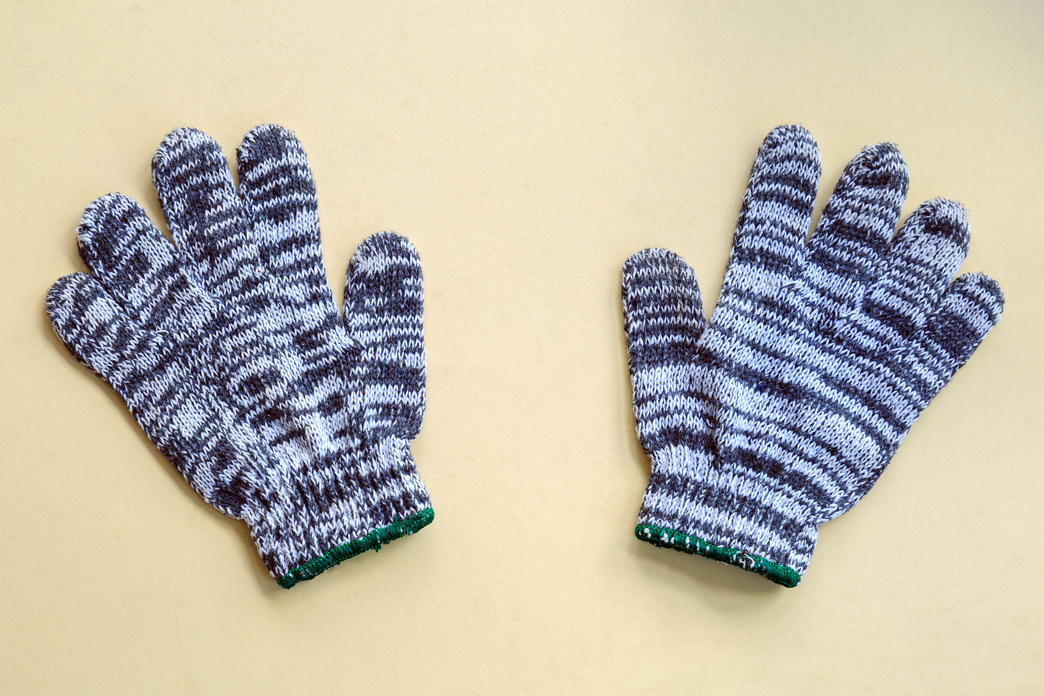 fabric gloves on beige wooden board.