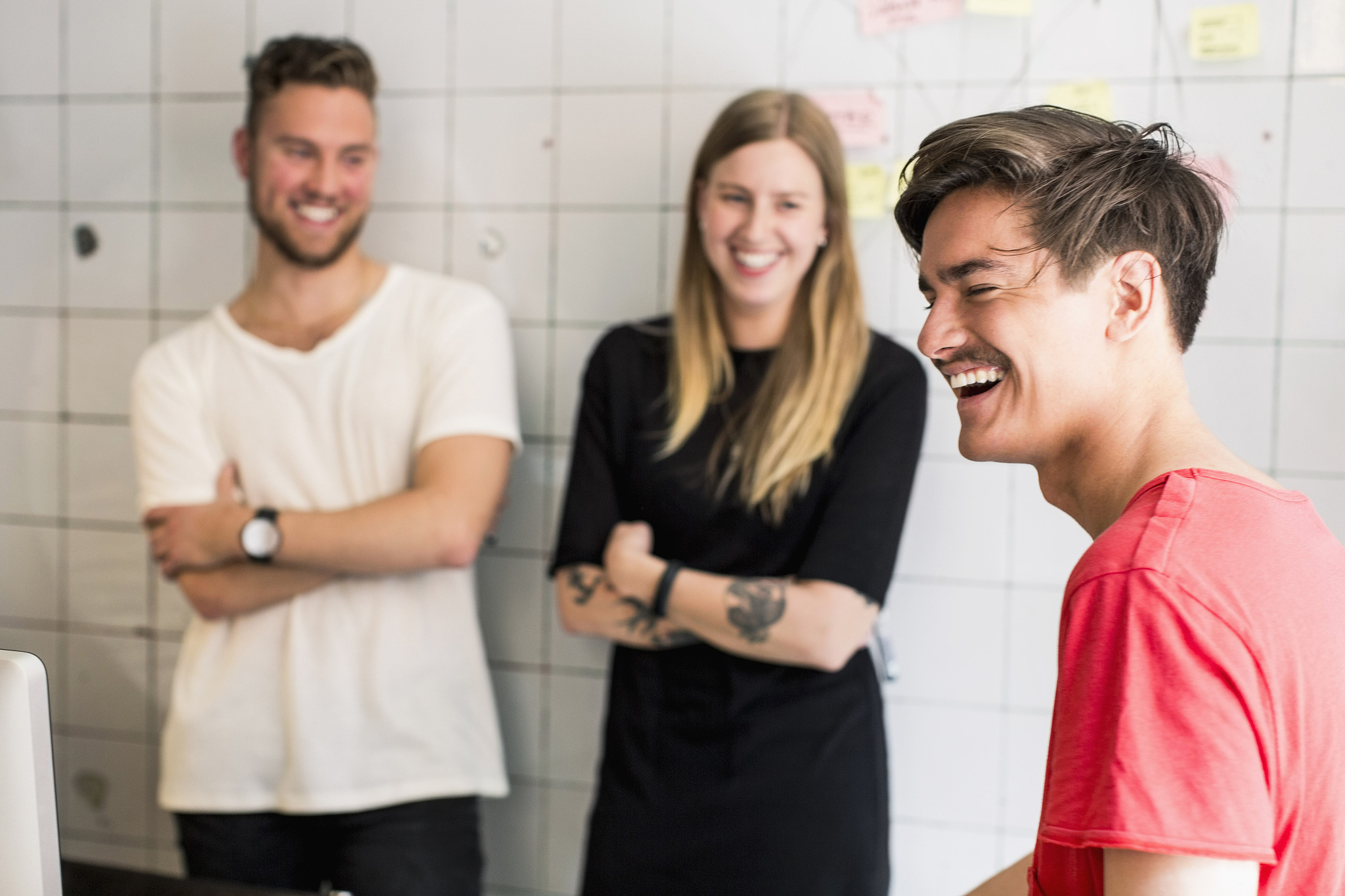 smiling young businessman with colleagues in background at new o