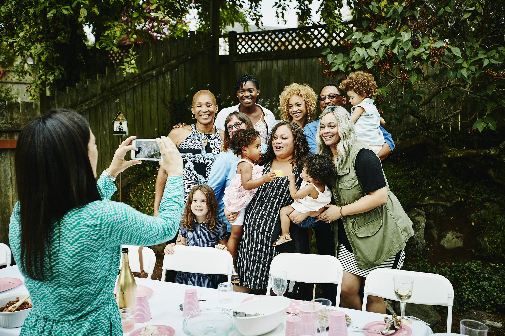 woman taking photo with smartphone of family