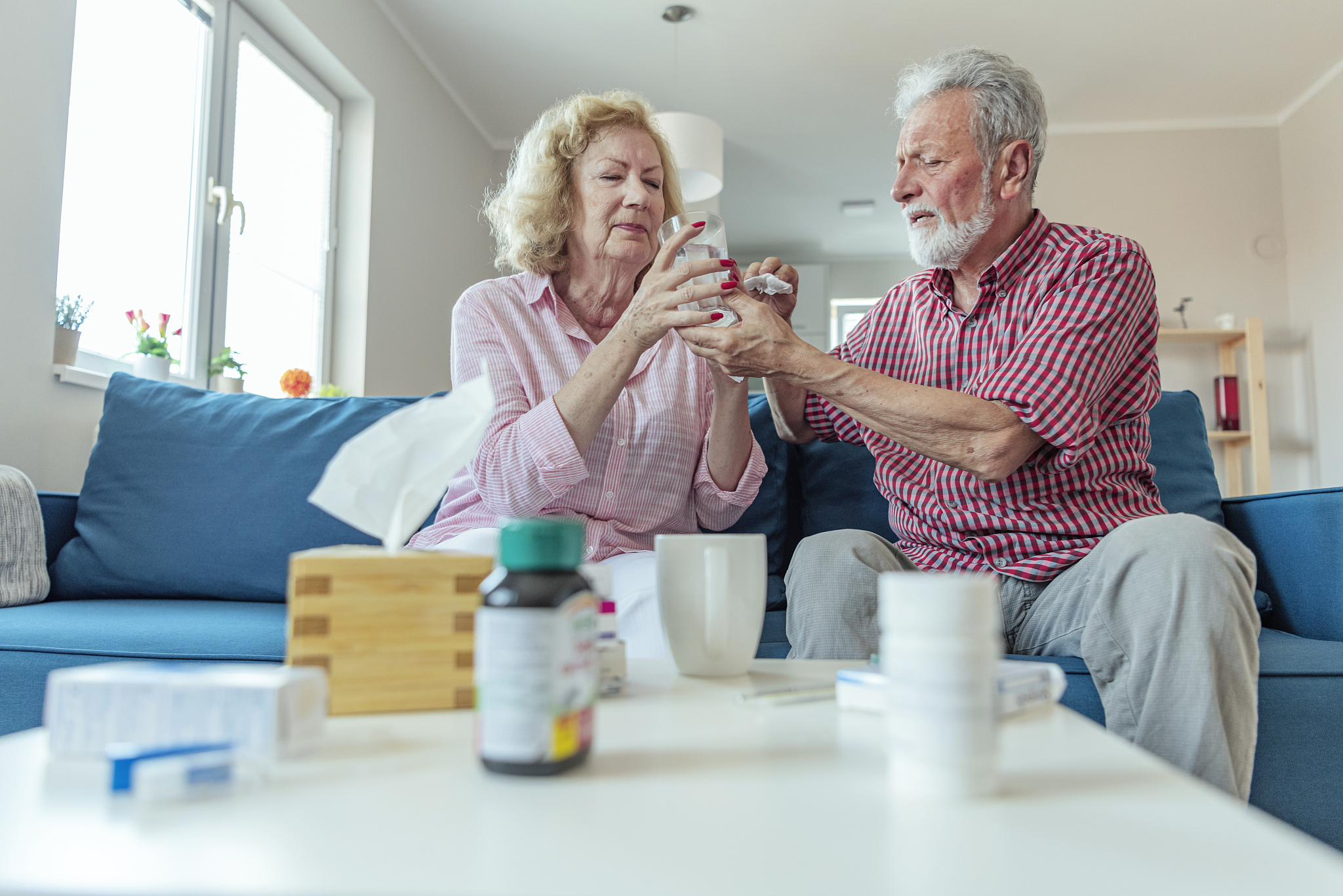 senior husband helping his ill spouse