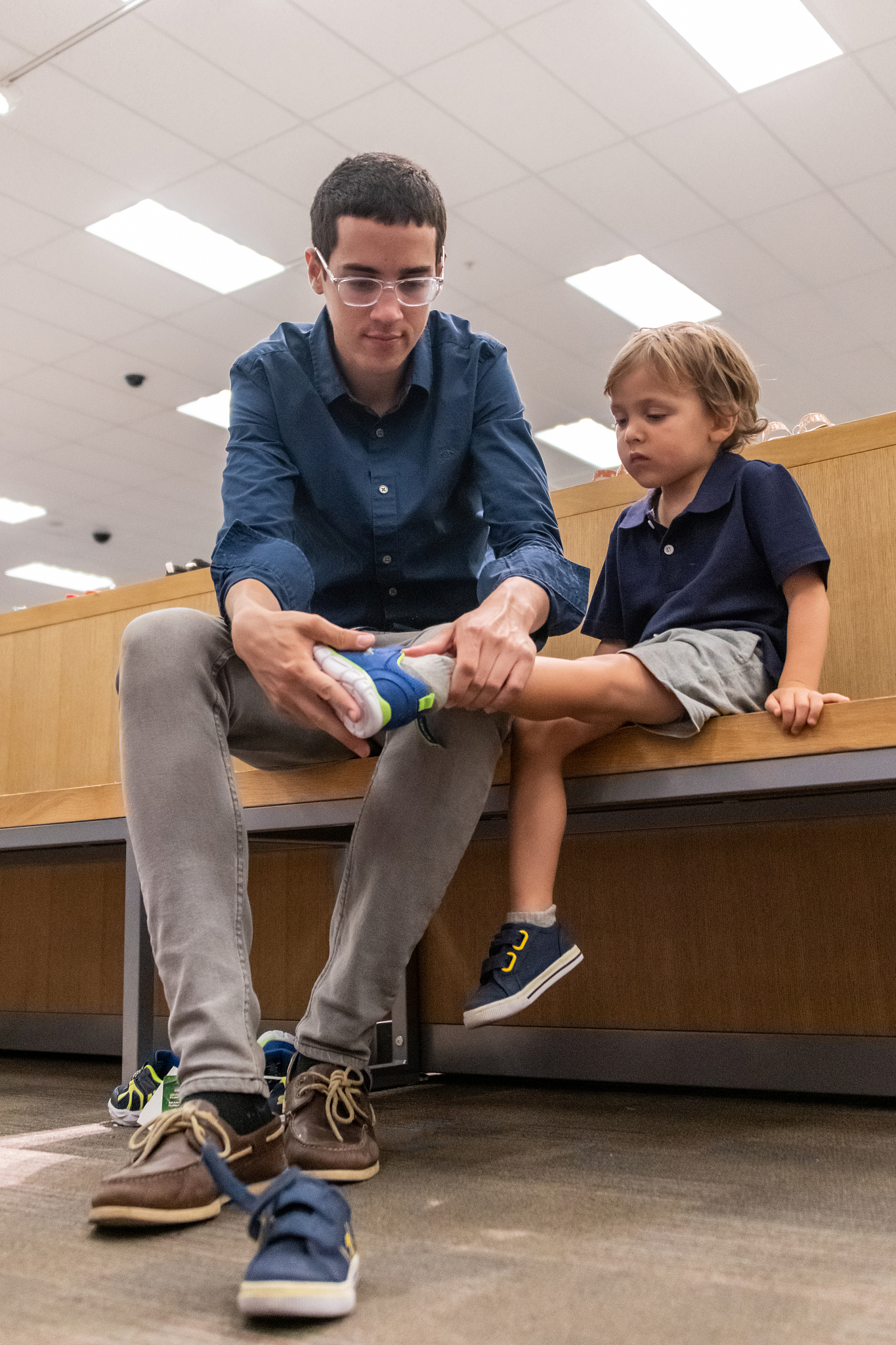 young man shopping for shoes for his son