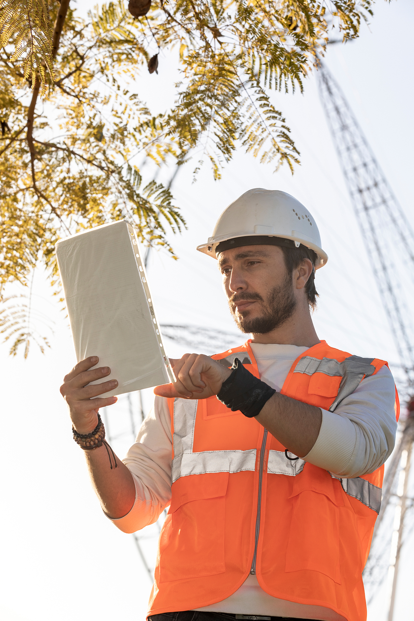 construction engineer controlling datasheet and wearing safety h