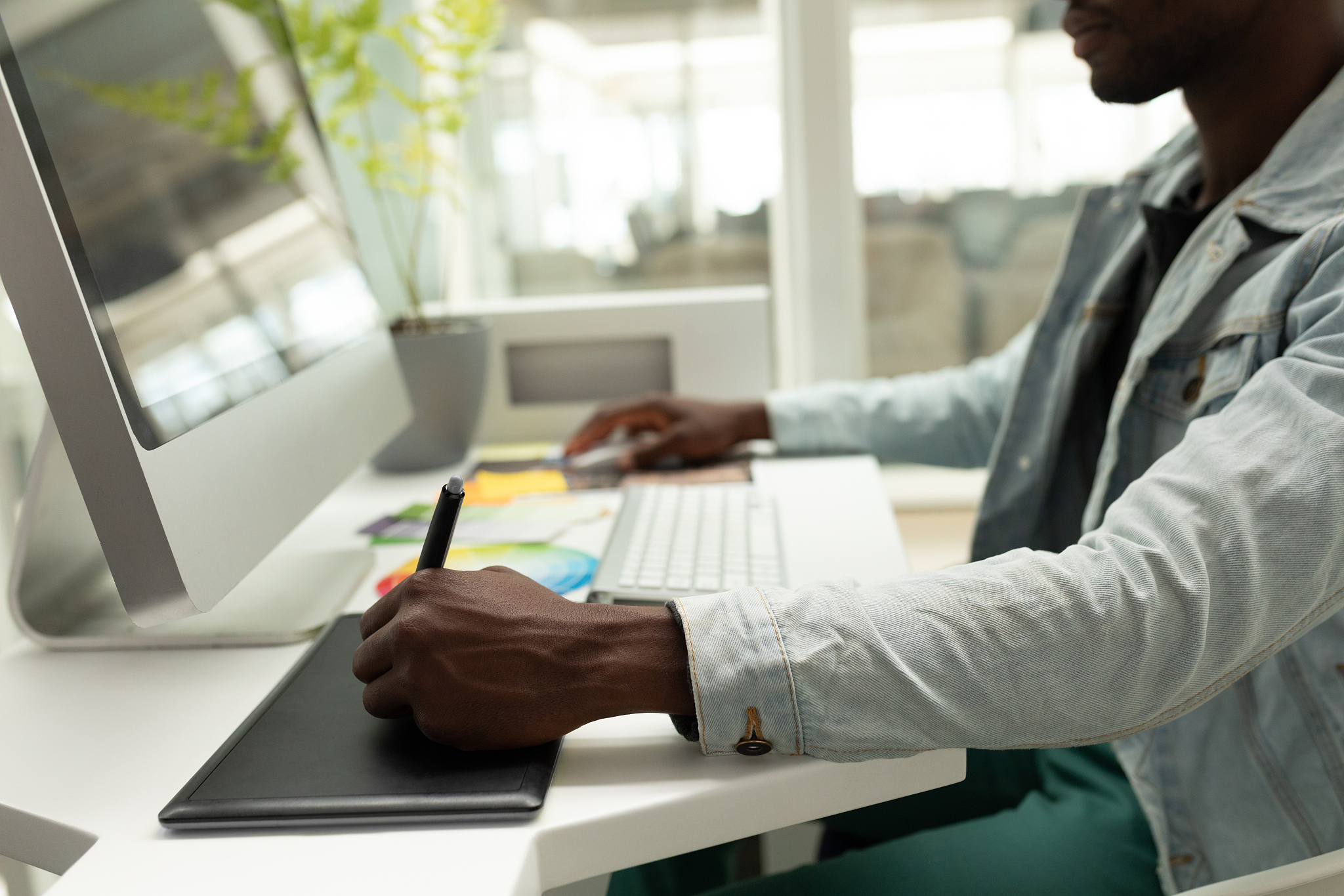 male graphic designer using graphic tablet at desk