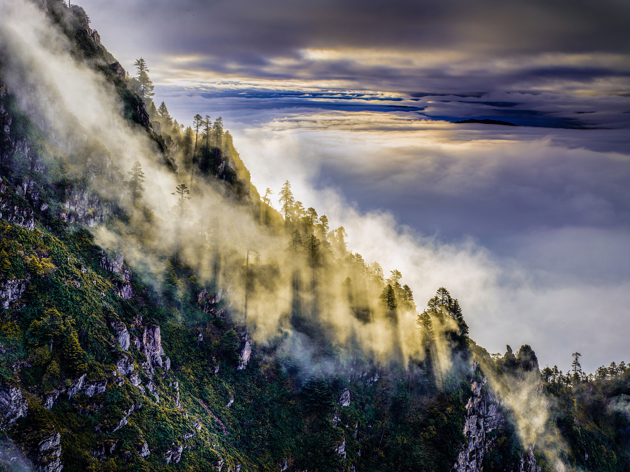 请用100字形容一下山峰被云笼罩的场景