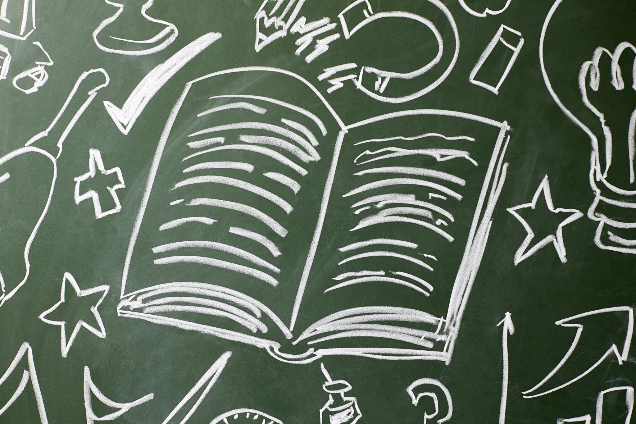 open book and symbols drawn on a chalkboard, copy space
