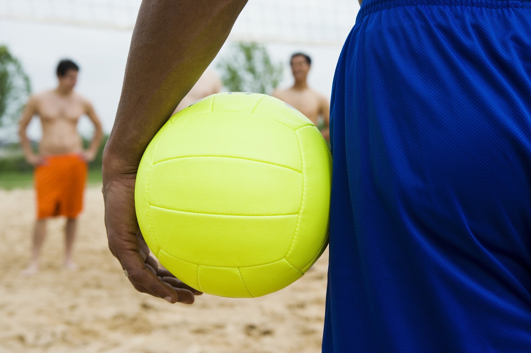 man holding a beach volleyball