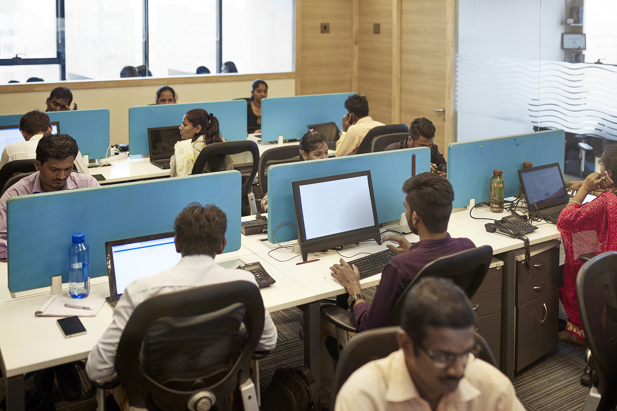indian office workers sitting in front of their computers