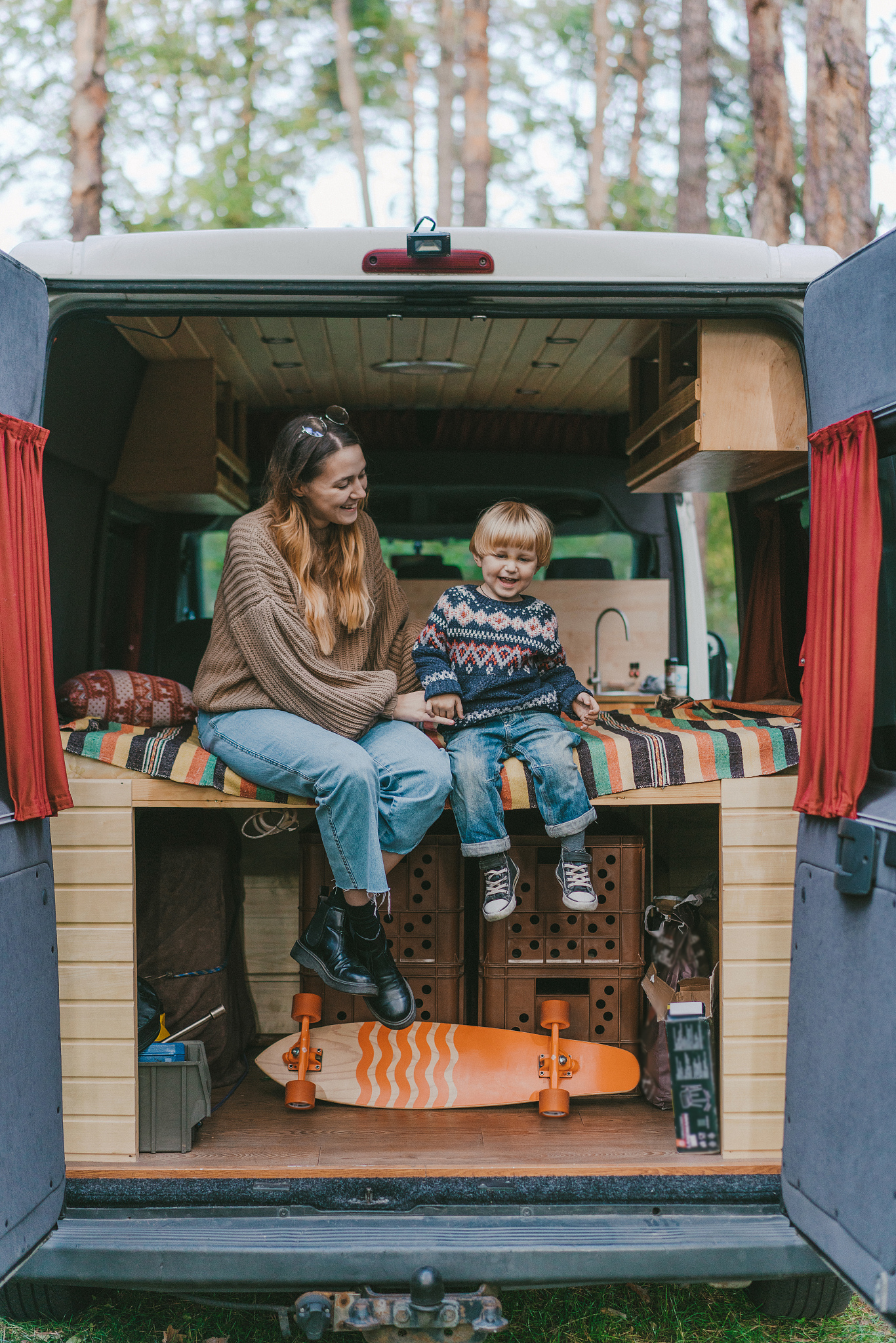 woman with son sitting in camper van