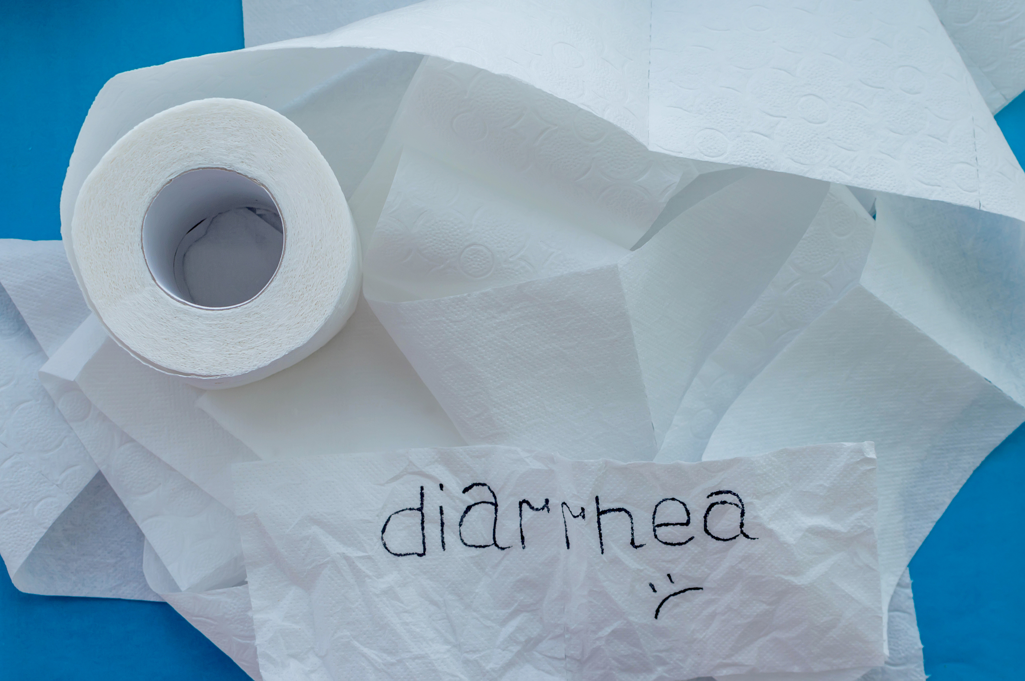 a roll of white toilet paper labeled "diarrhea" on a blue backgr