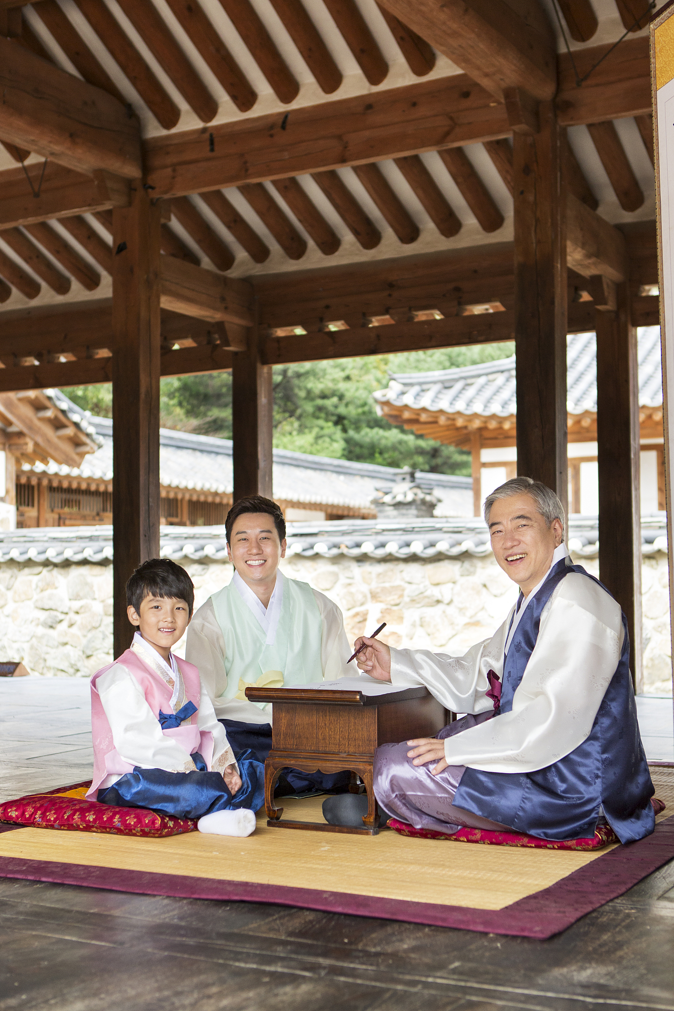 photography of 3 generations family wearing hanbok sitting on th