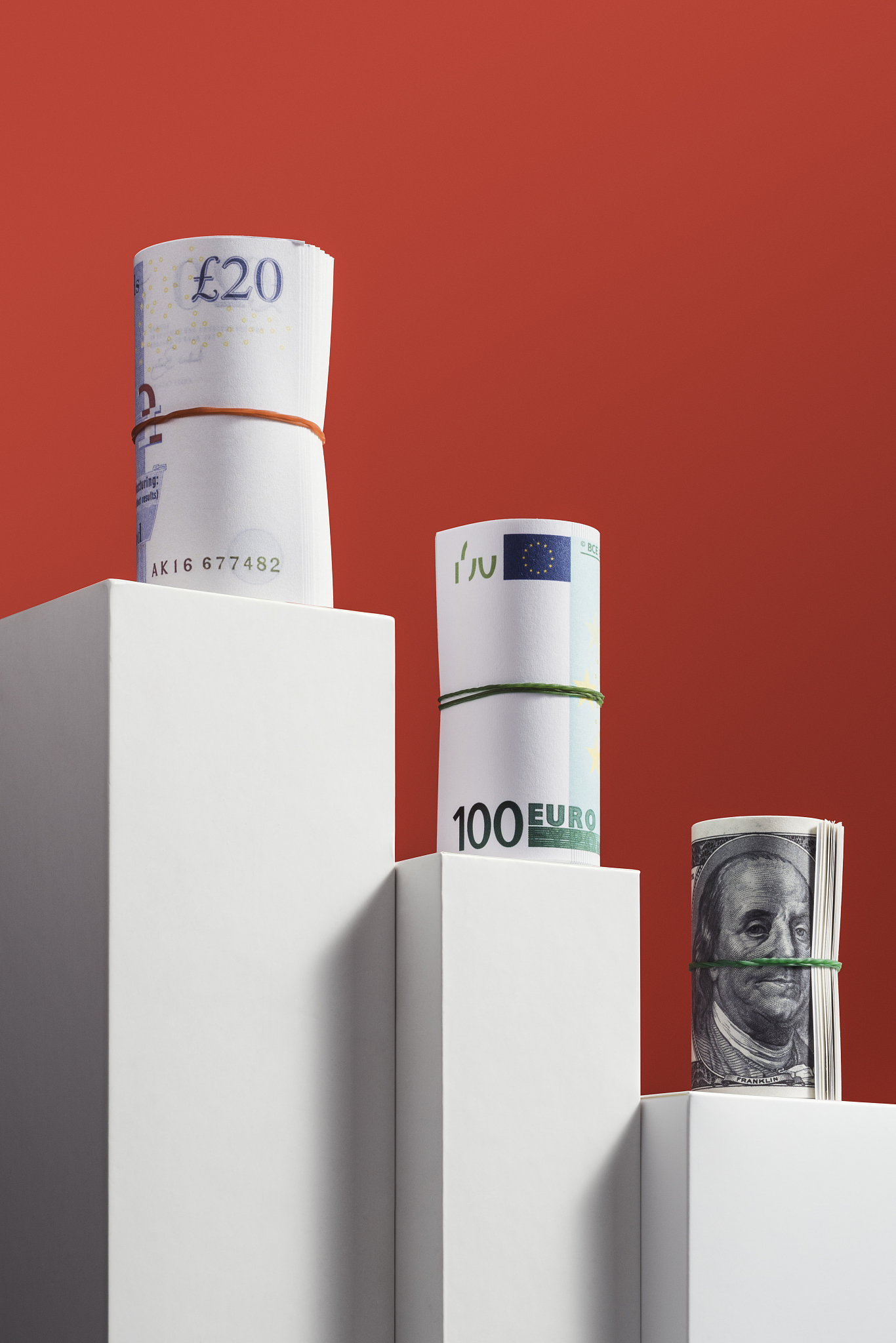 pound, euro, dollar rolls on red background