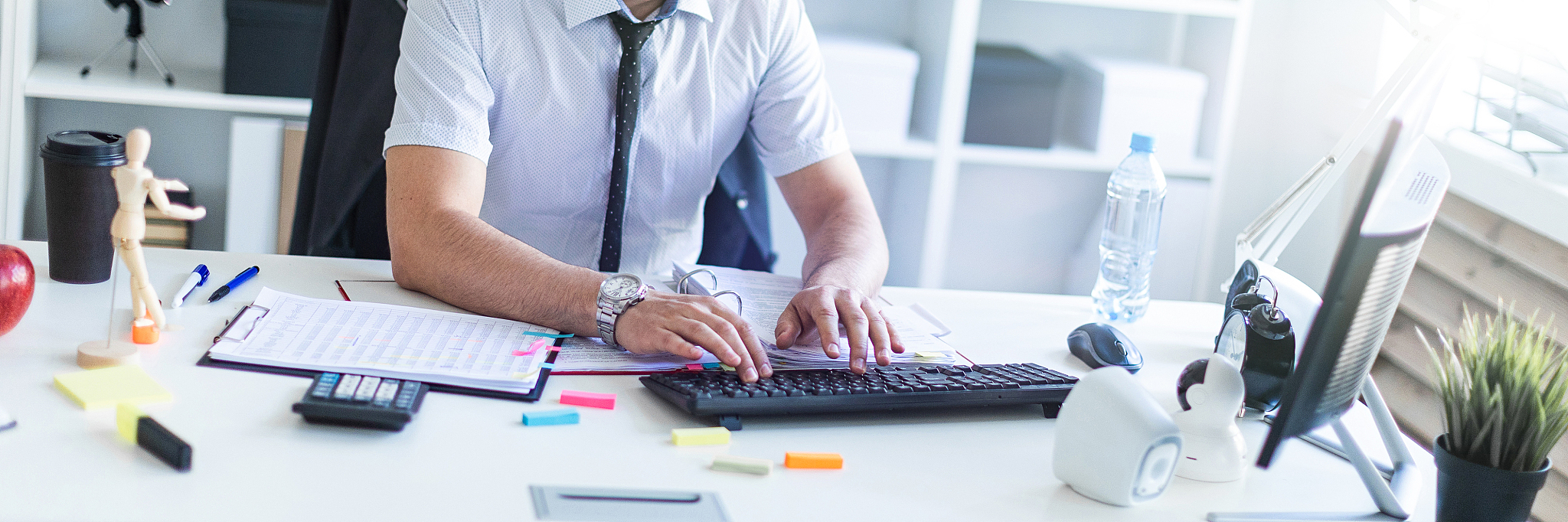 a man is sitting at a table in the office, working with document