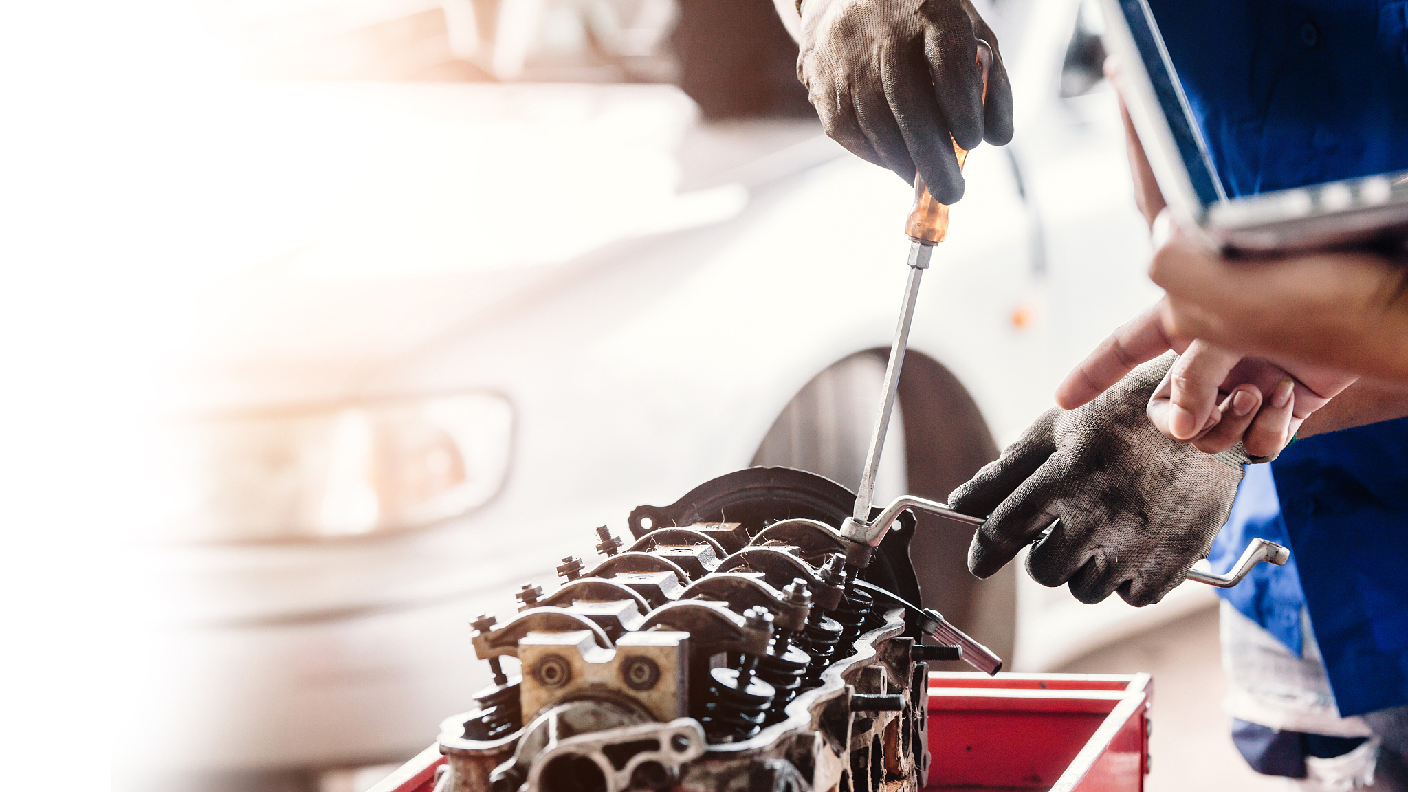 mechanic with a tool in his hands repairing the motor of the mac