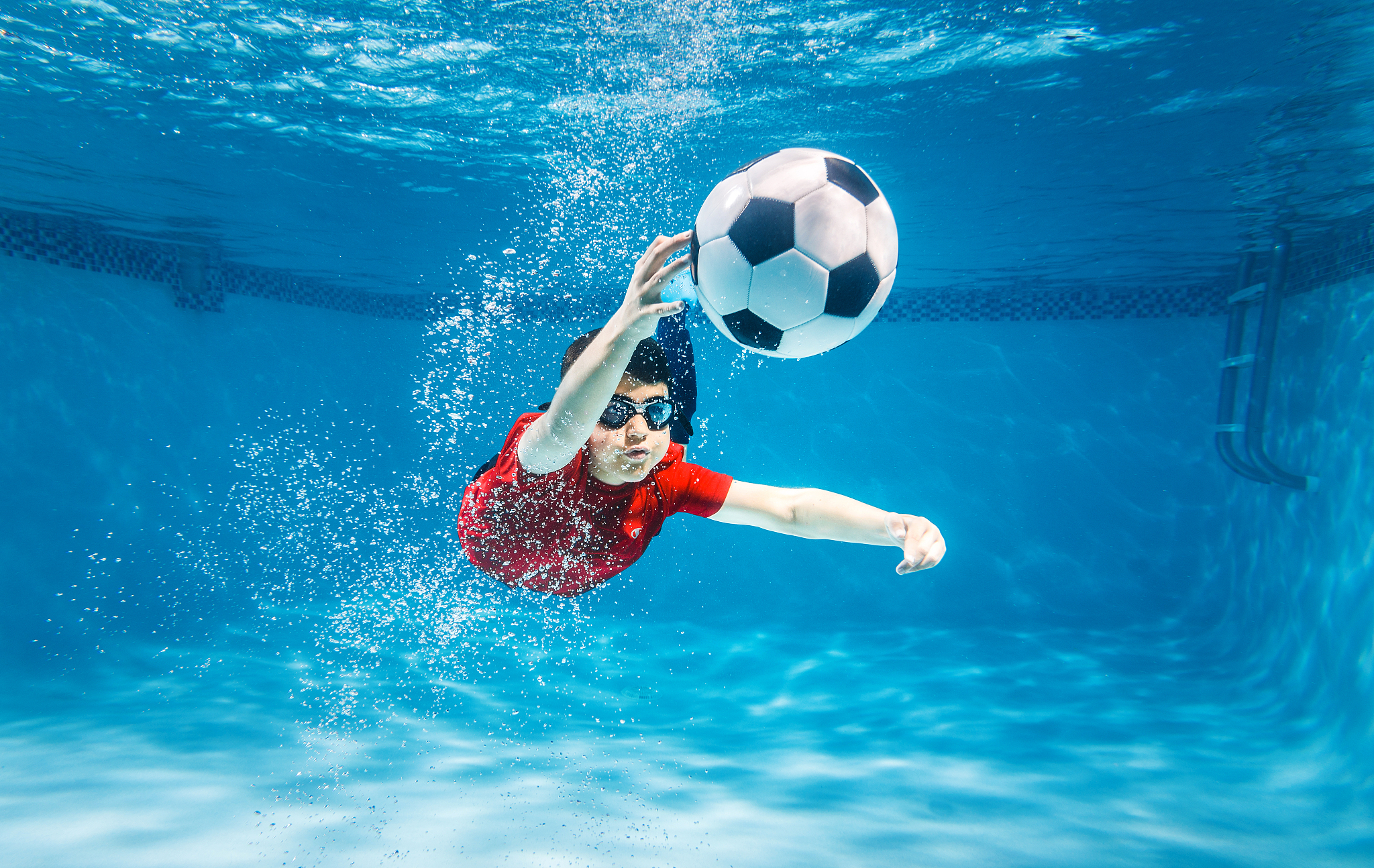 kid underwater soccer