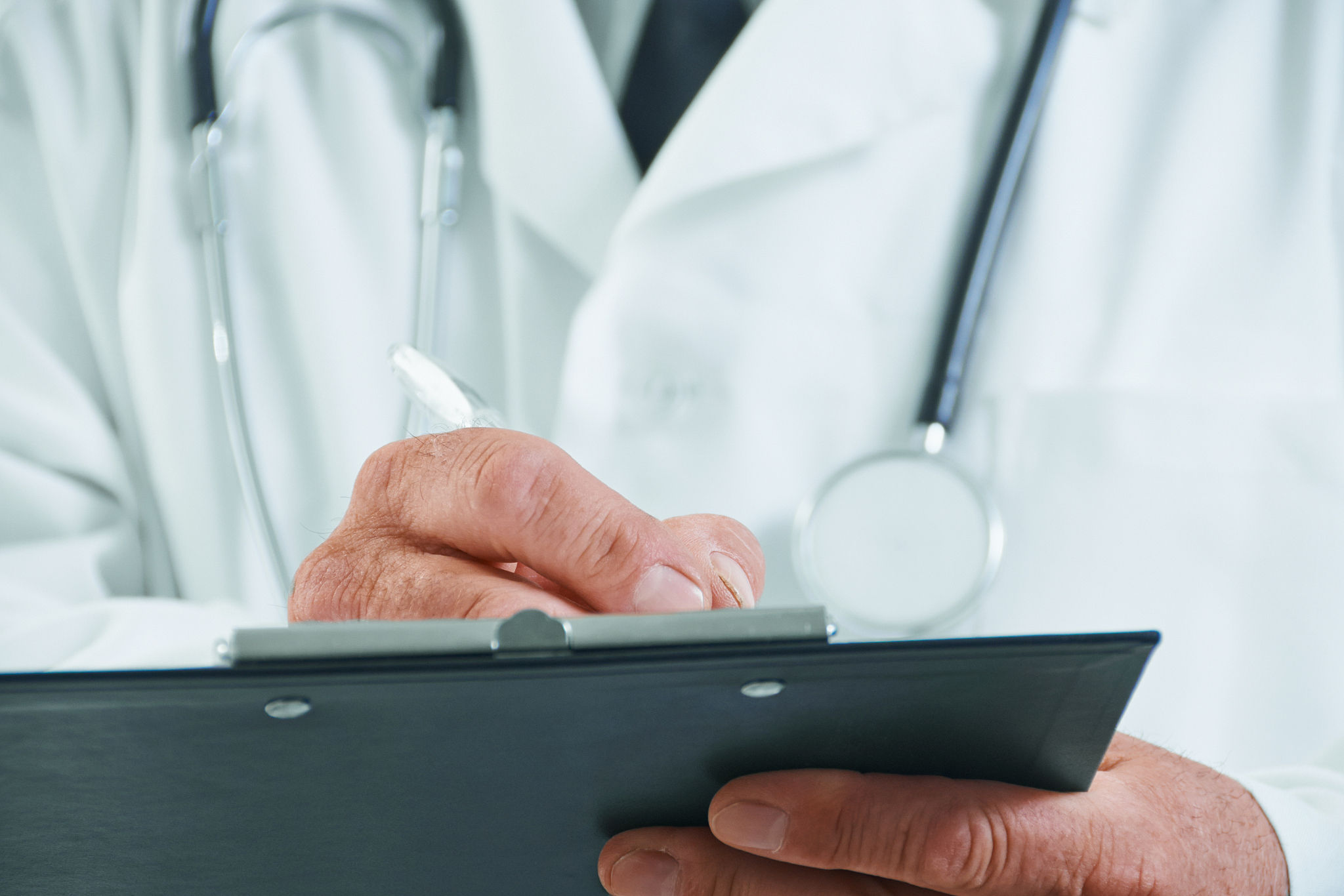 older doctor writes medical notes