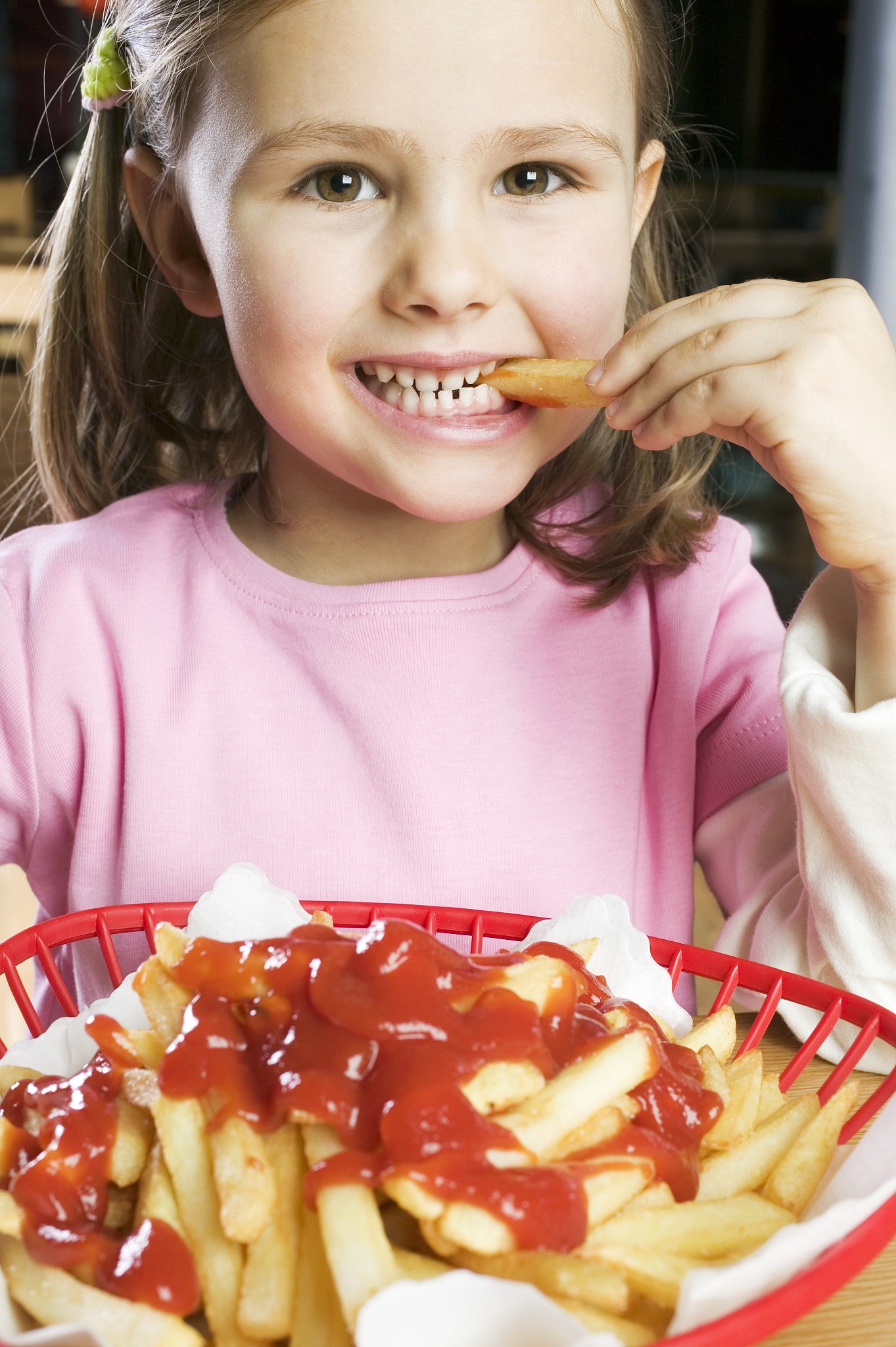 girl eating chips with ketchup