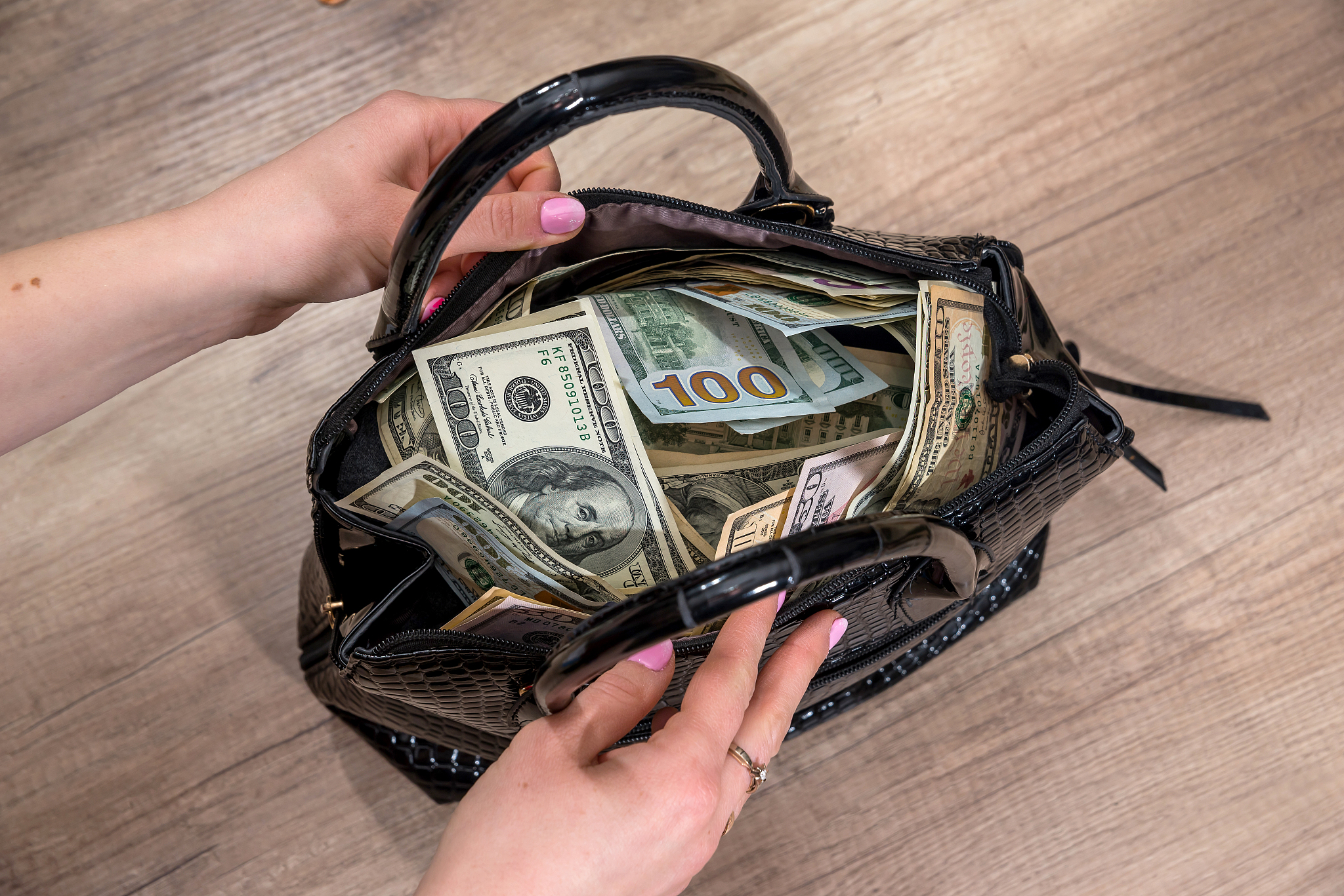 girl extract dollars from the full-packed bags of money.