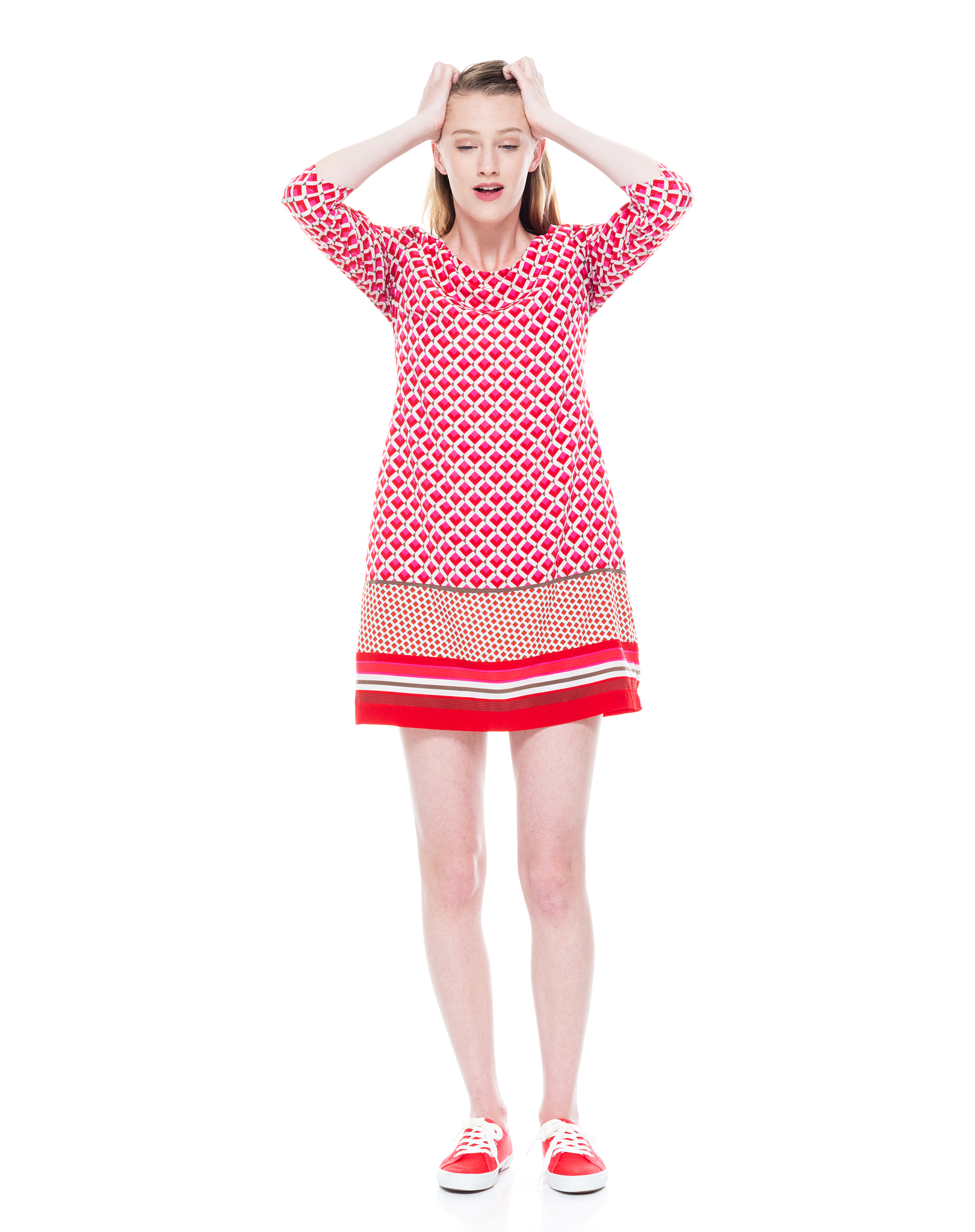 caucasian female standing in front of white background wearing d