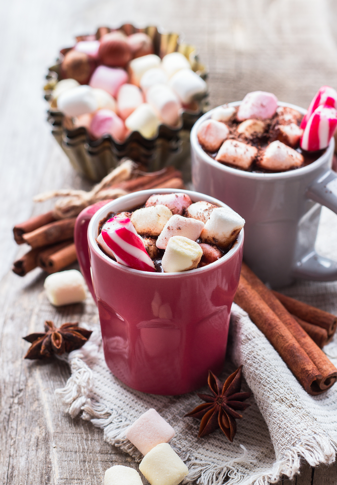 hot chocolate with marshmallows and spices on rustic wooden tabl