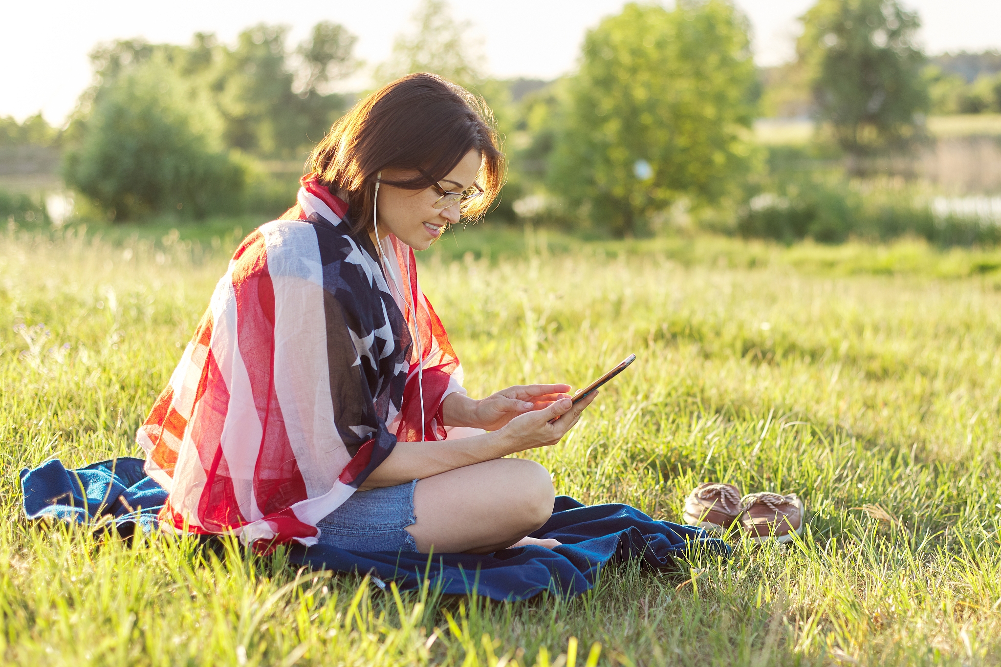 adult woman sitting on july evening in nature with usa flag scar