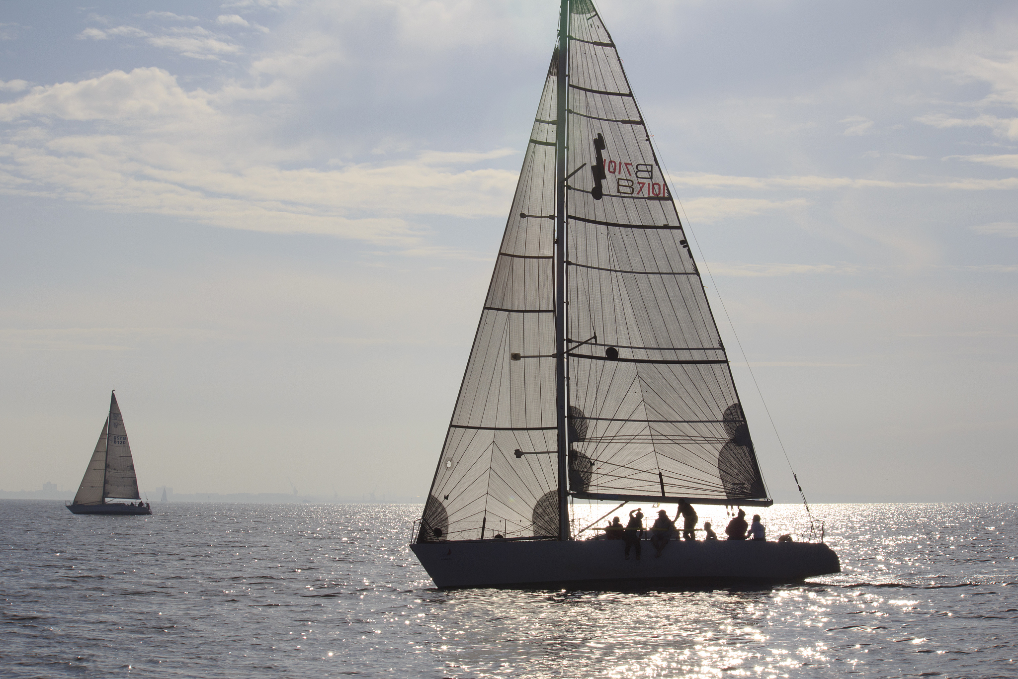 yacht sailing on port phillip bay silhouetted by the reflecting 