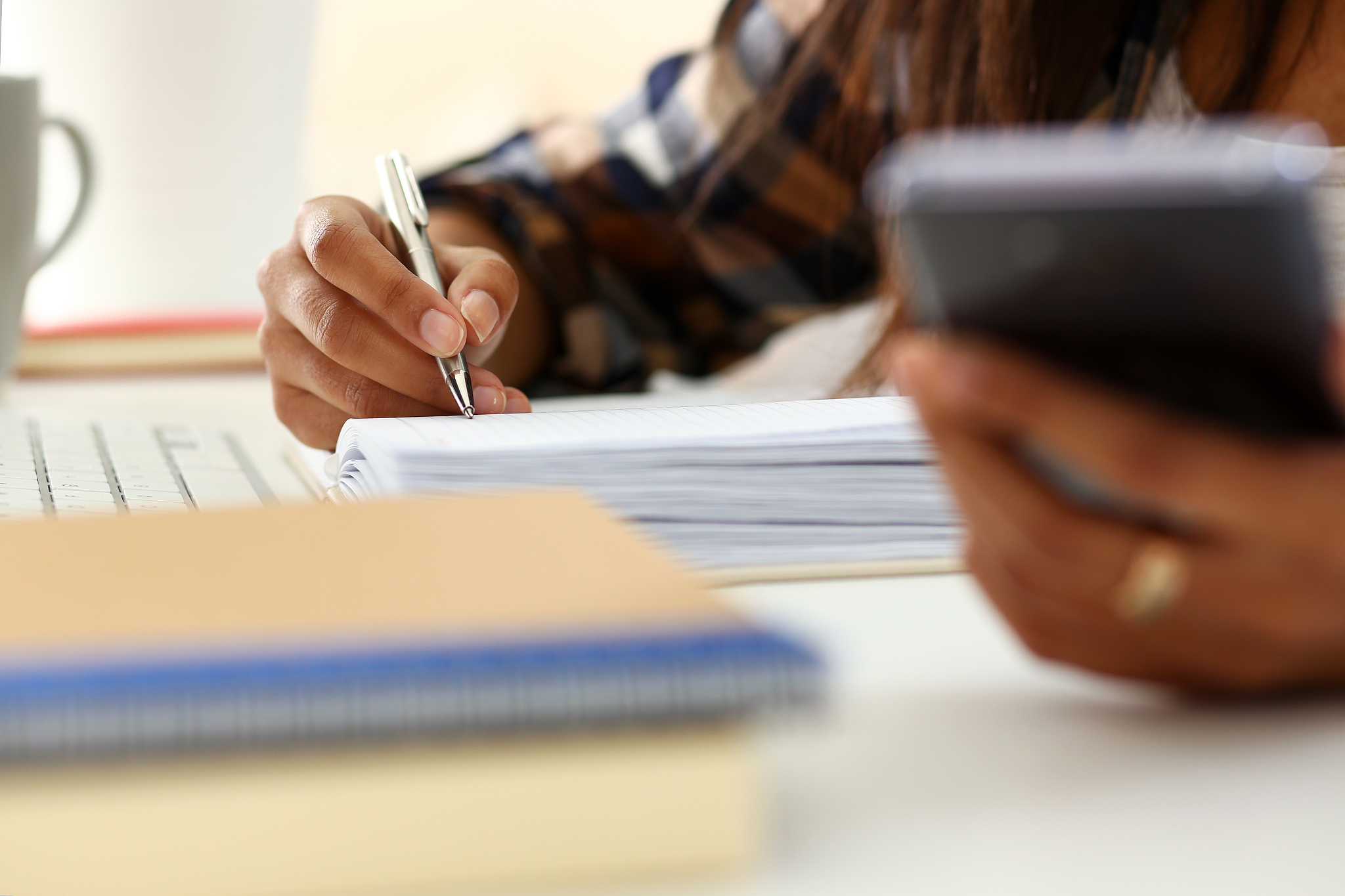 arm of black woman hold silver pen workplace writing something