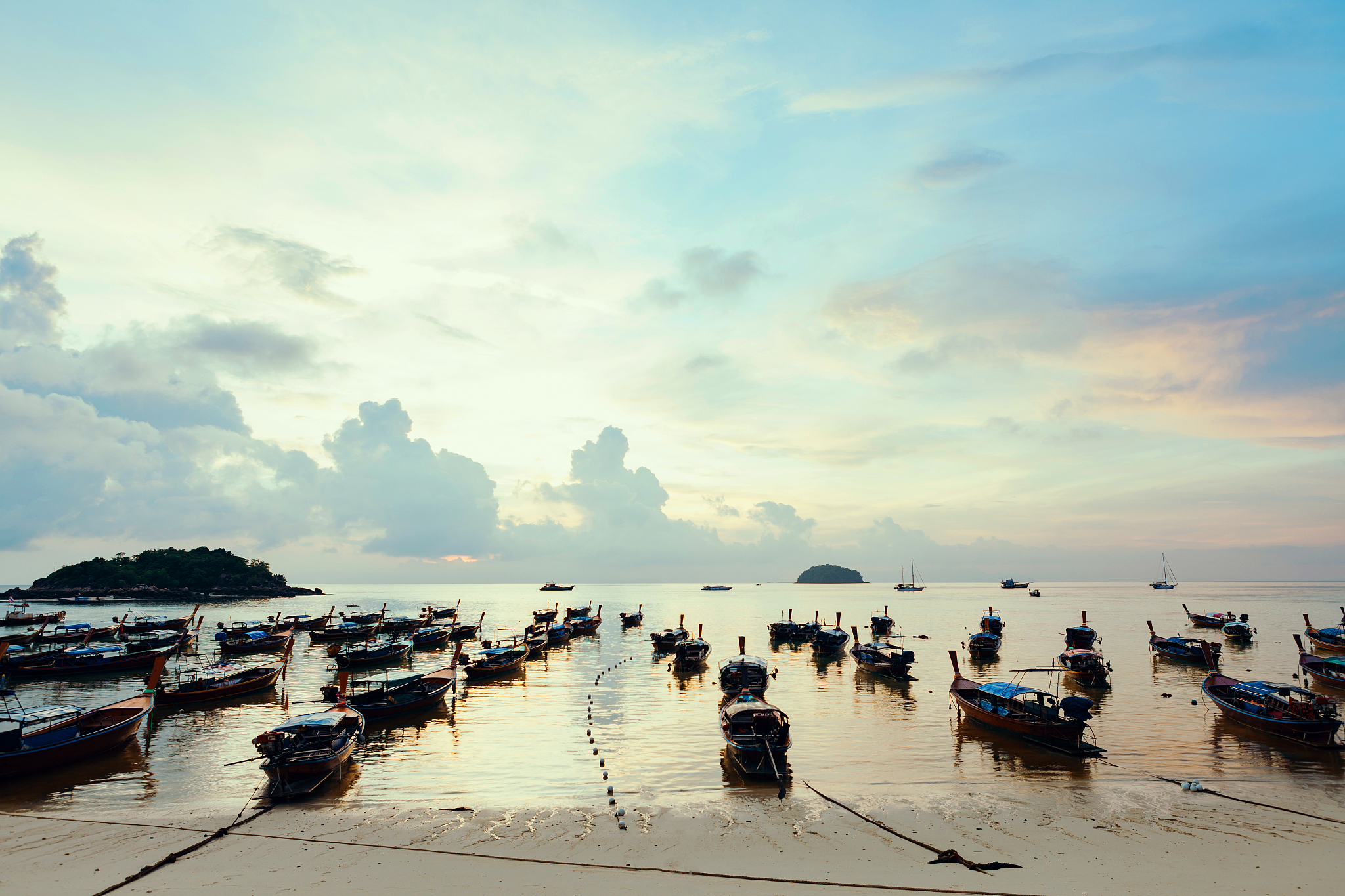 beautiful sea and beach with over group of long tail boats.