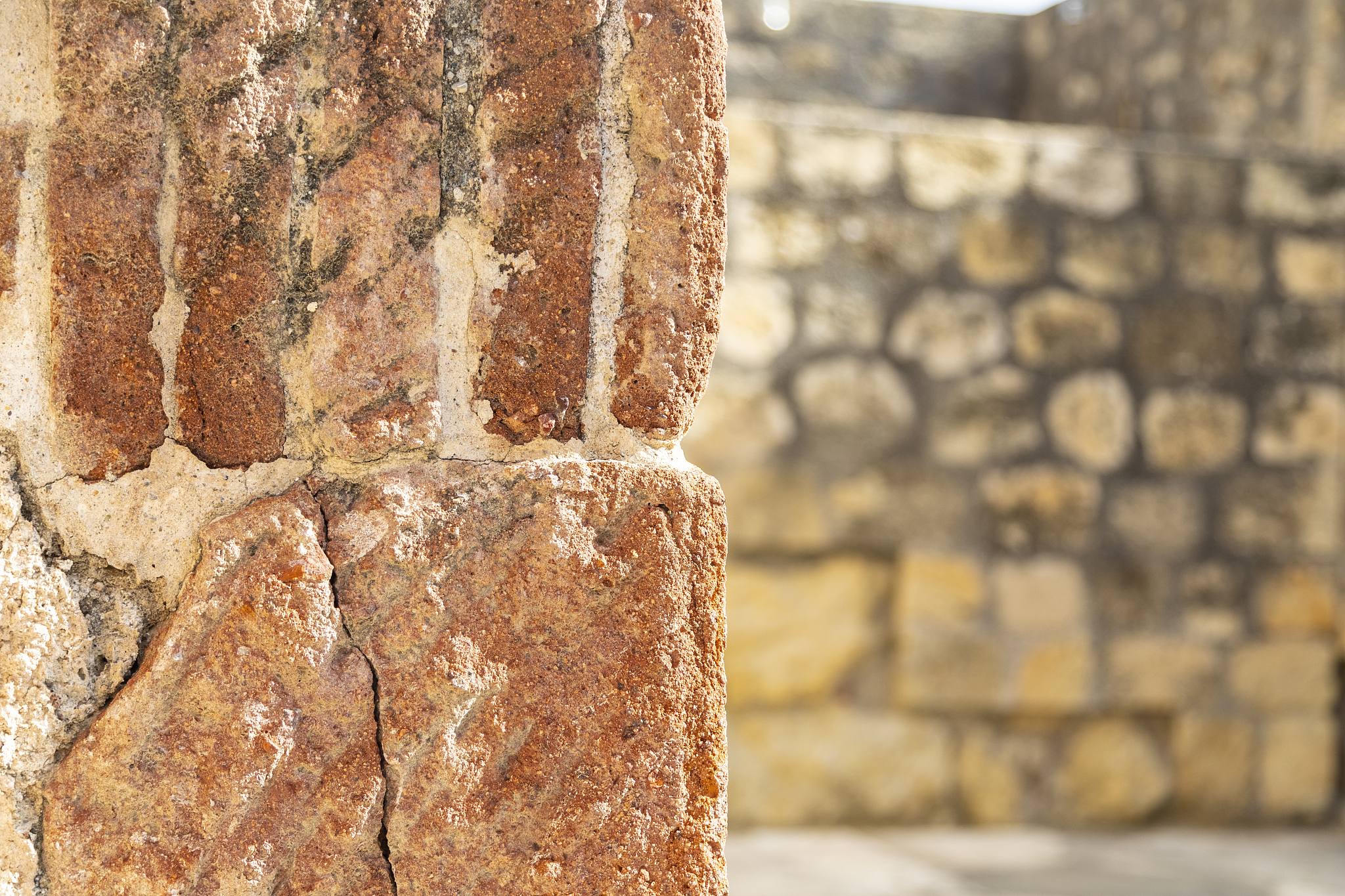 fragment of wall with wall with stones at background.