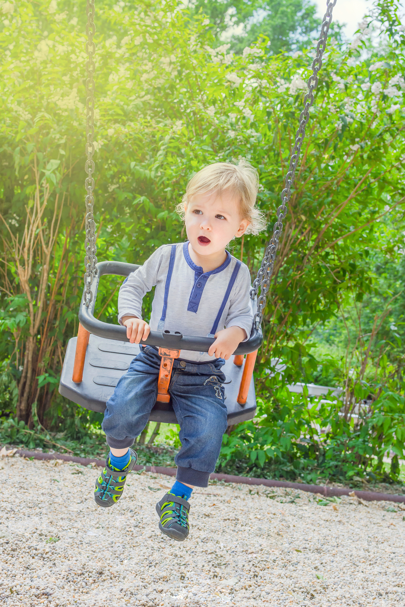 cute little child having fun on a swing in the park. beautiful s